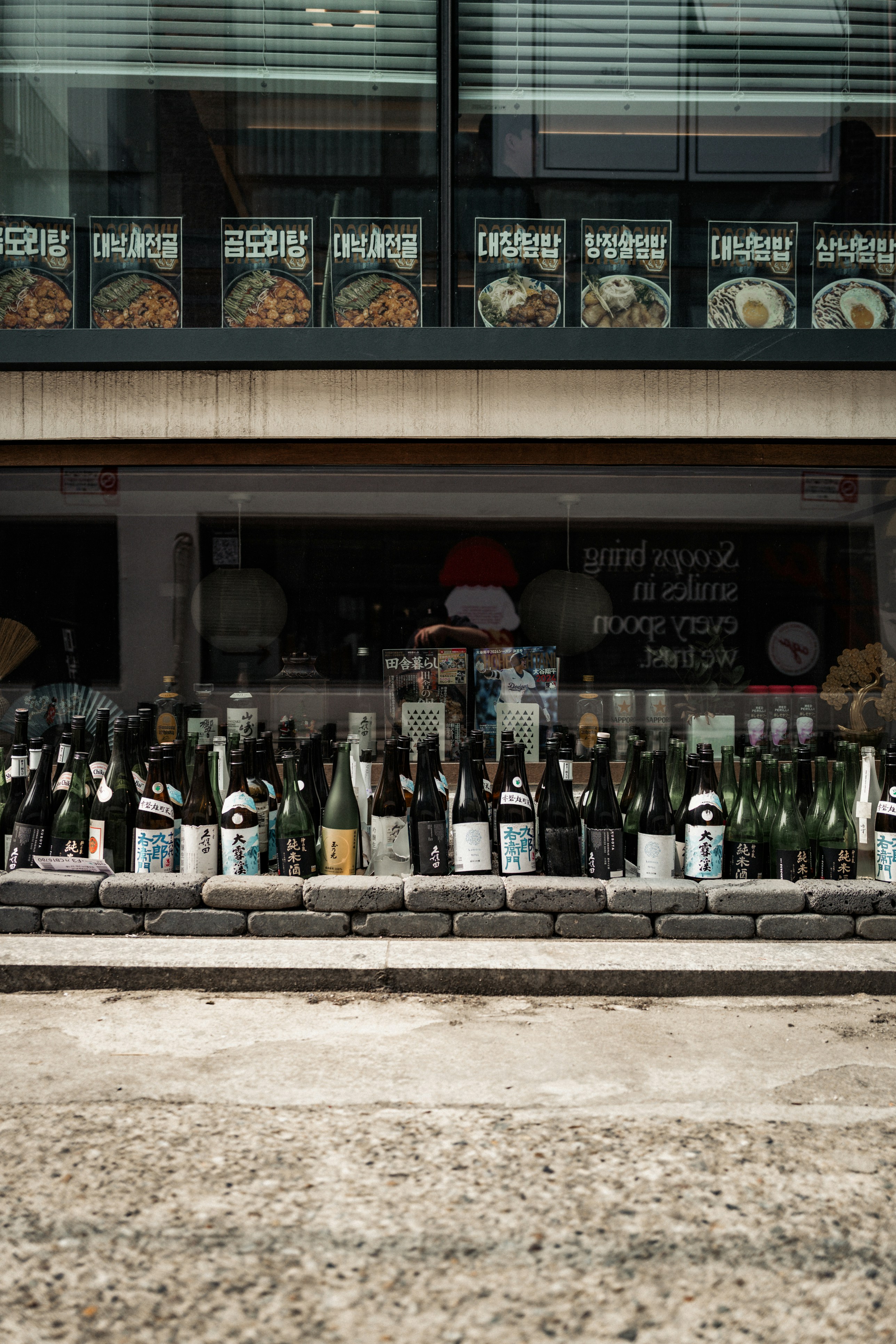 Bottles of sake displayed outside a japanese restaurant.