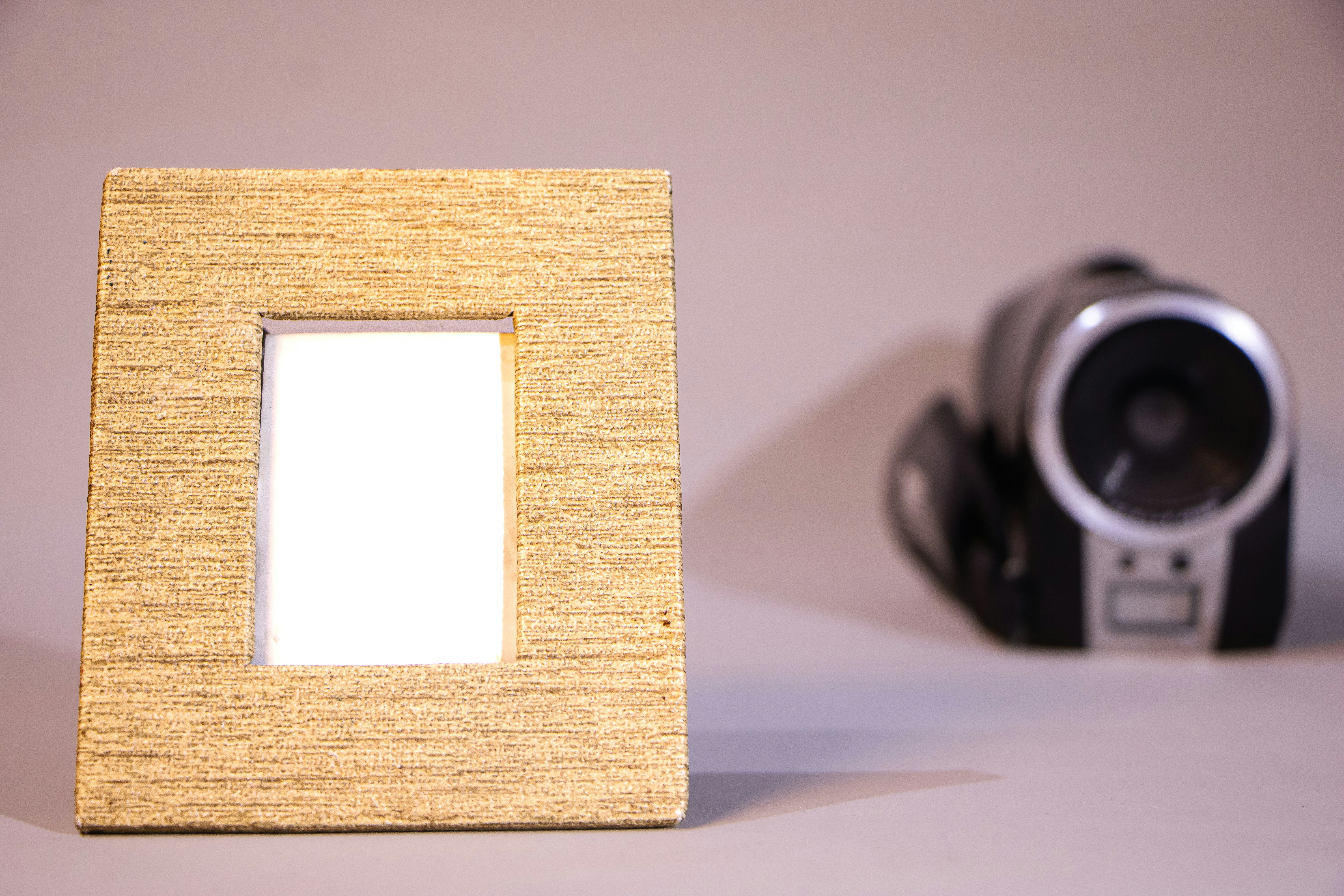 Wooden picture frame with a camcorder in background