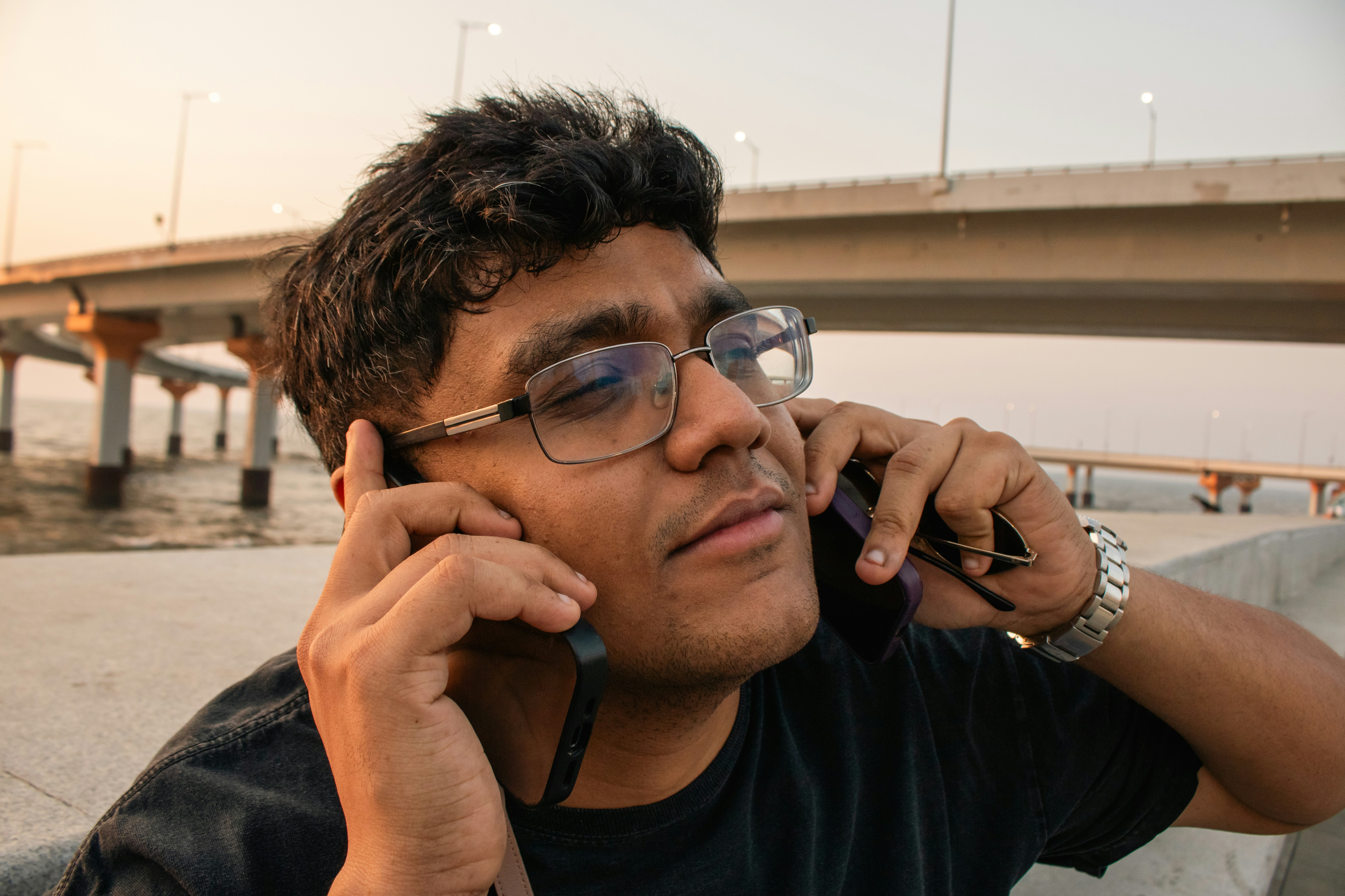 Uomo che tiene due telefoni alle orecchie