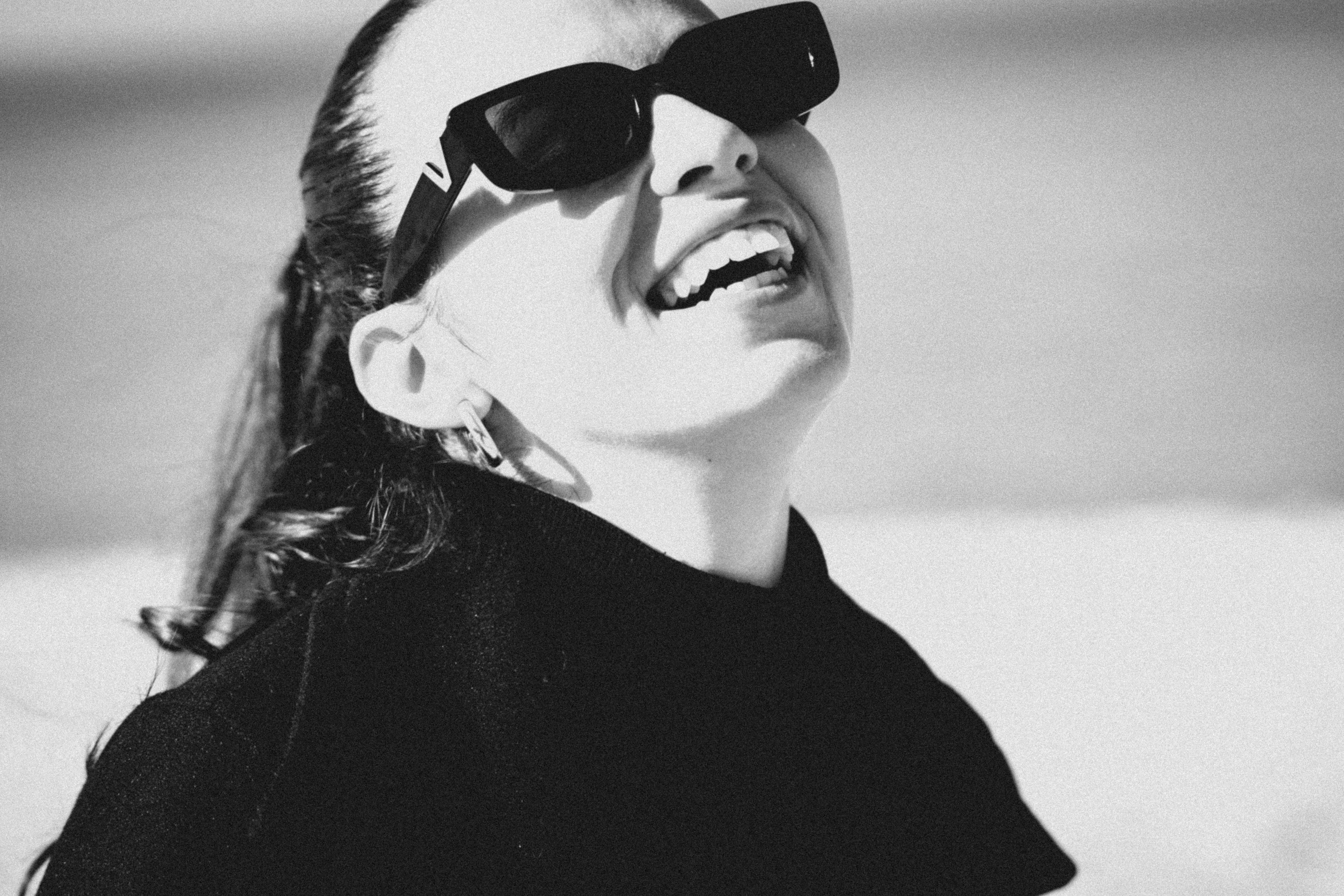 Woman in sunglasses laughing outdoors