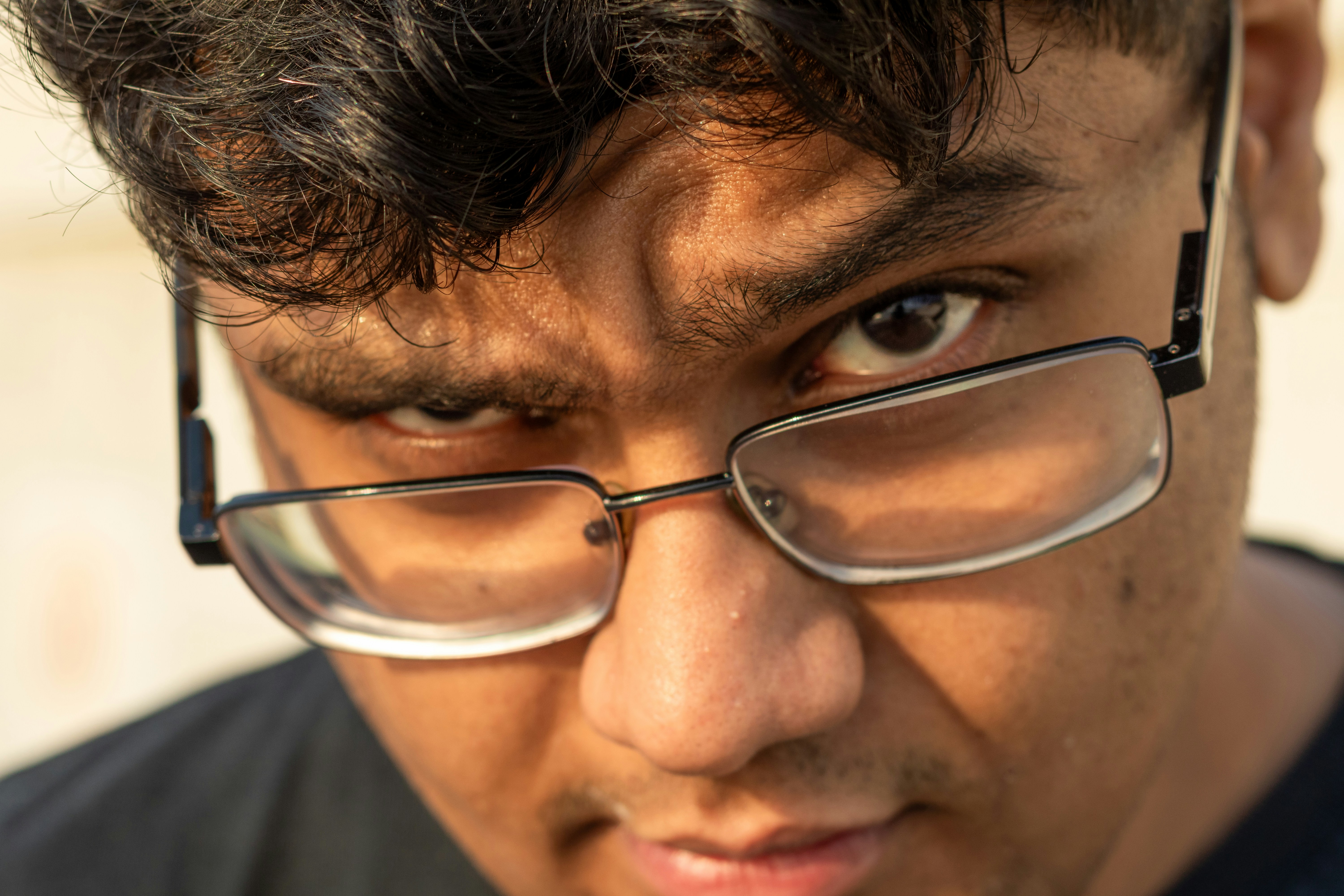 Close-up of a man wearing glasses looking intensely.