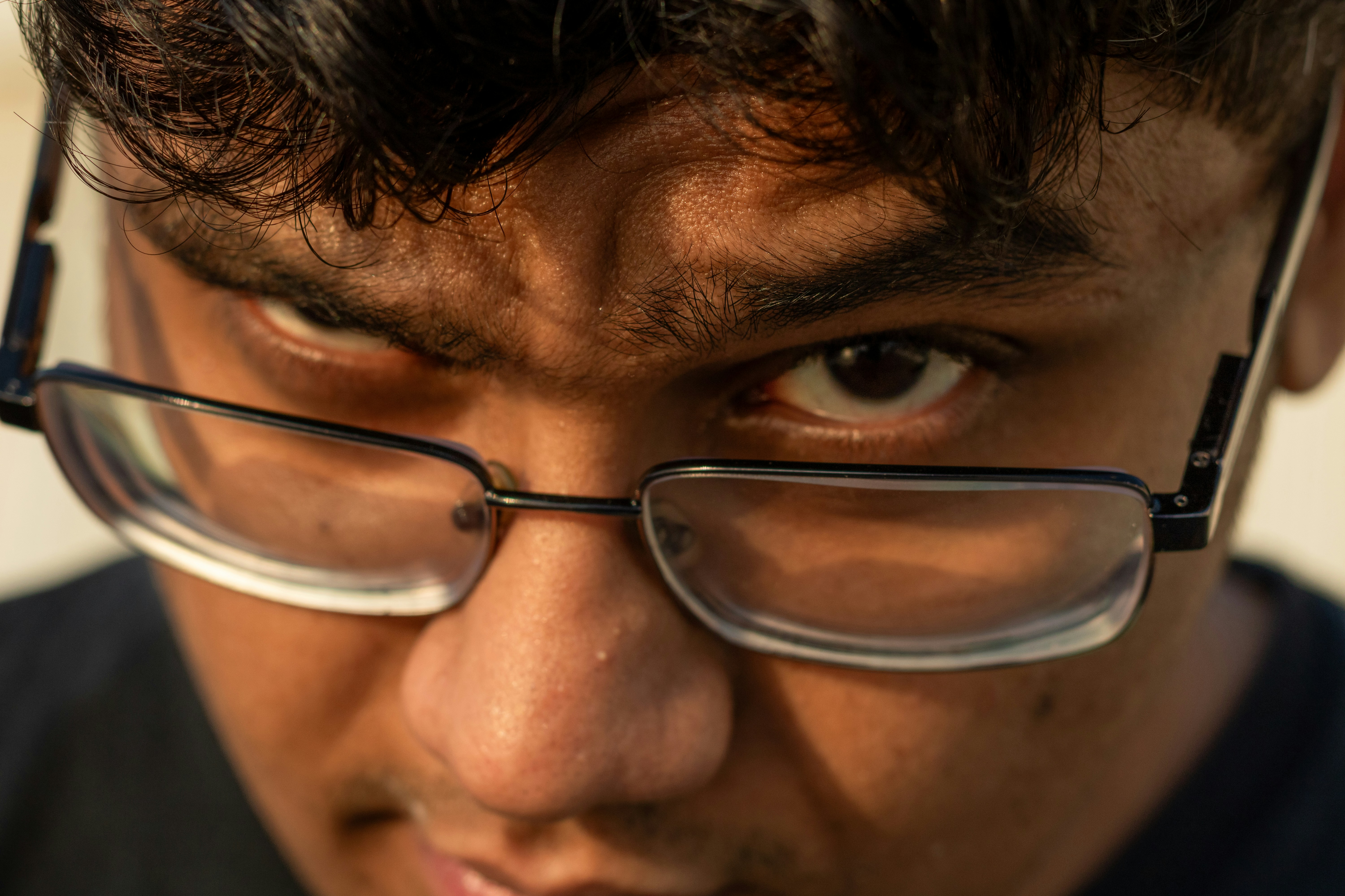 A close-up of a young man wearing glasses.