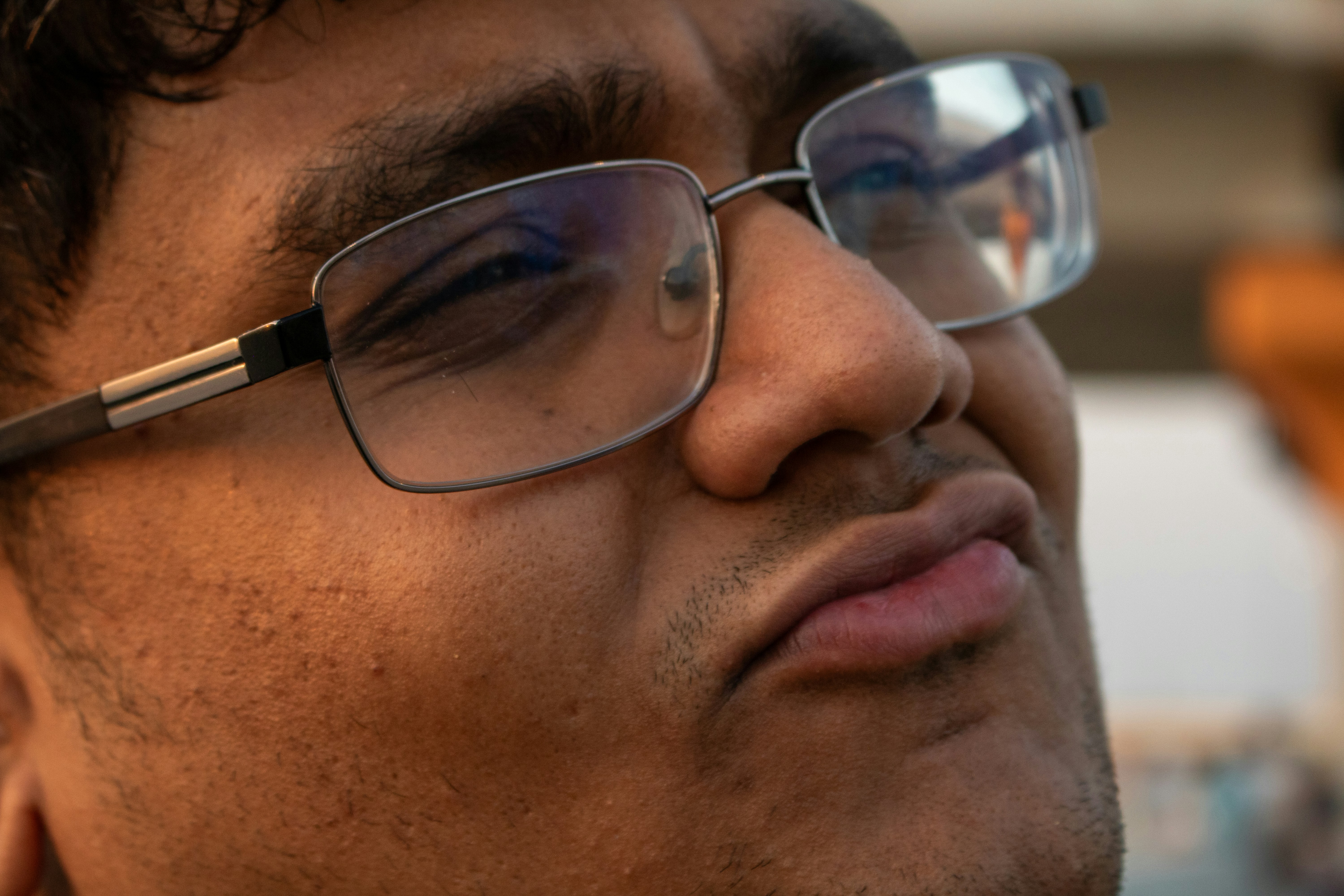 Man wearing glasses with a thoughtful expression.