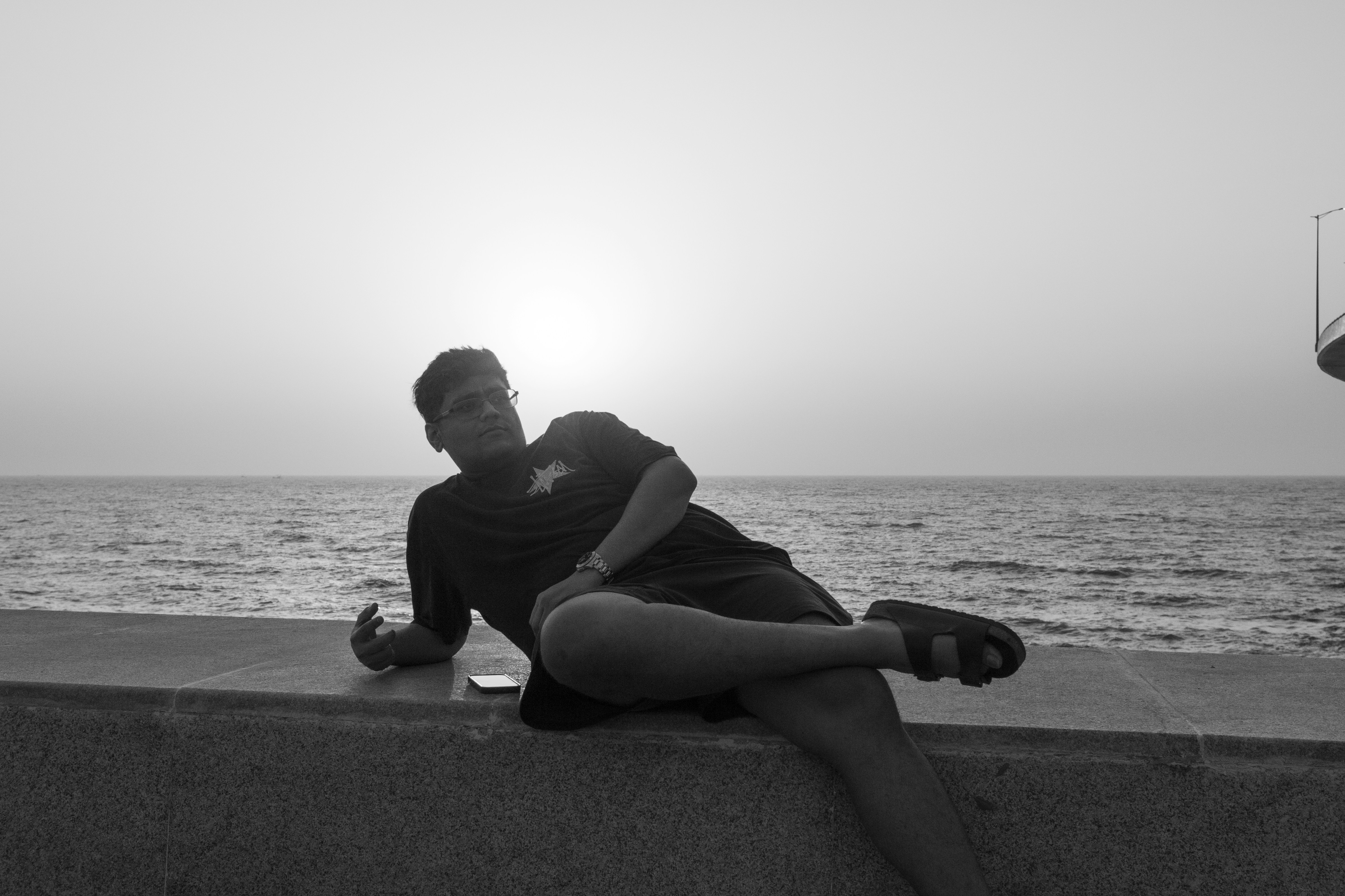 Man relaxing by the ocean at sunset