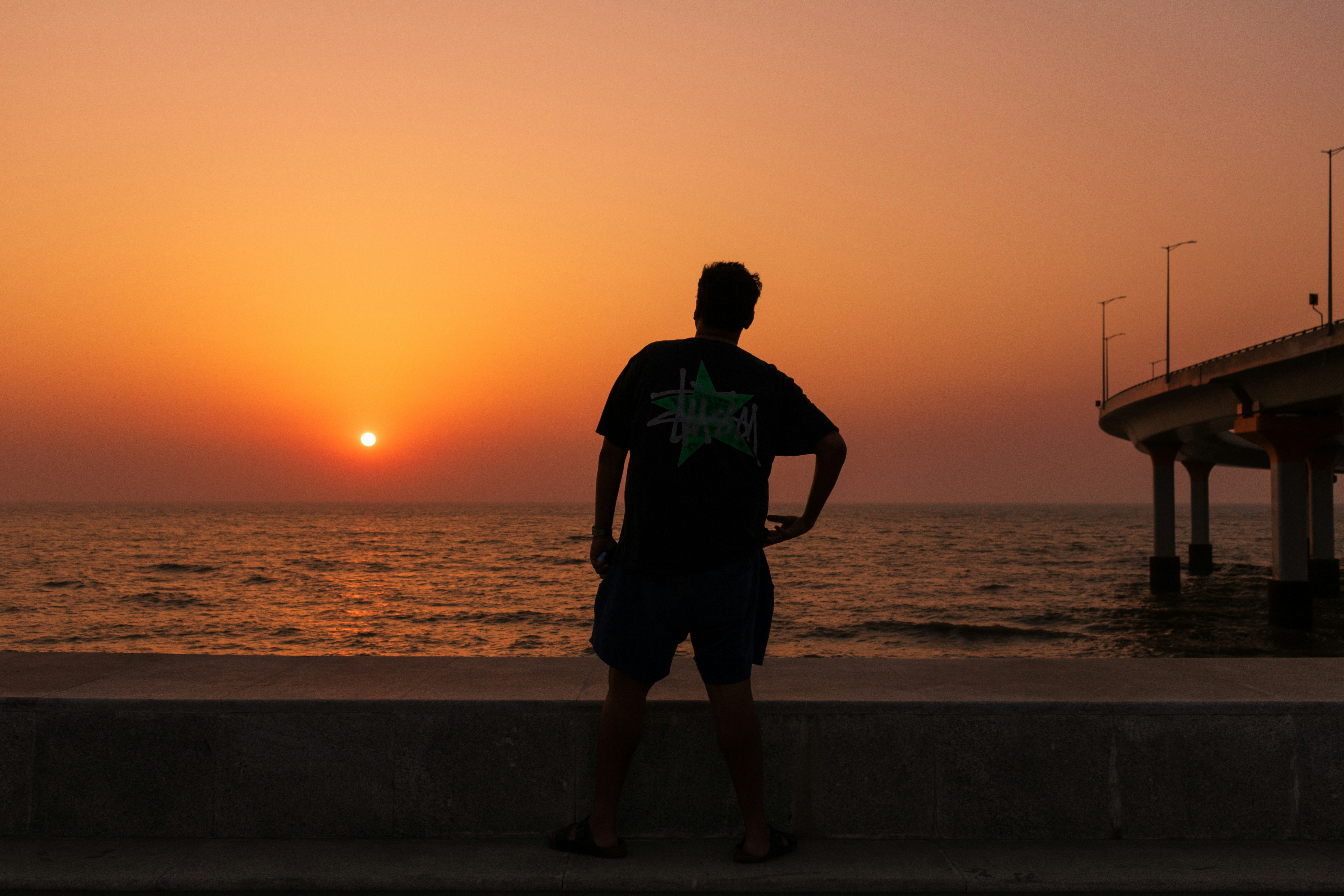 Silhouette of a person at sunset by the ocean