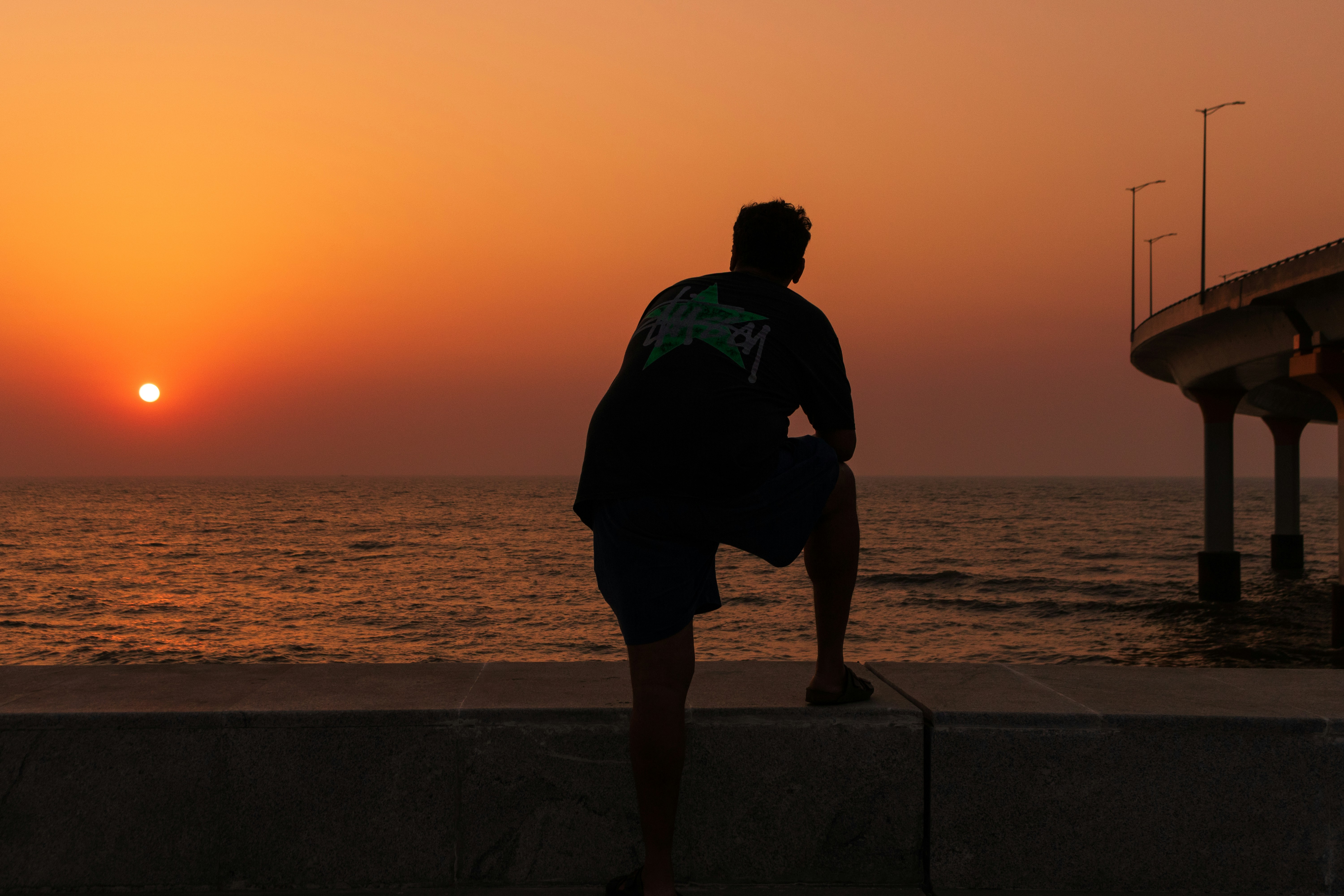 Man watching the sunset over the ocean