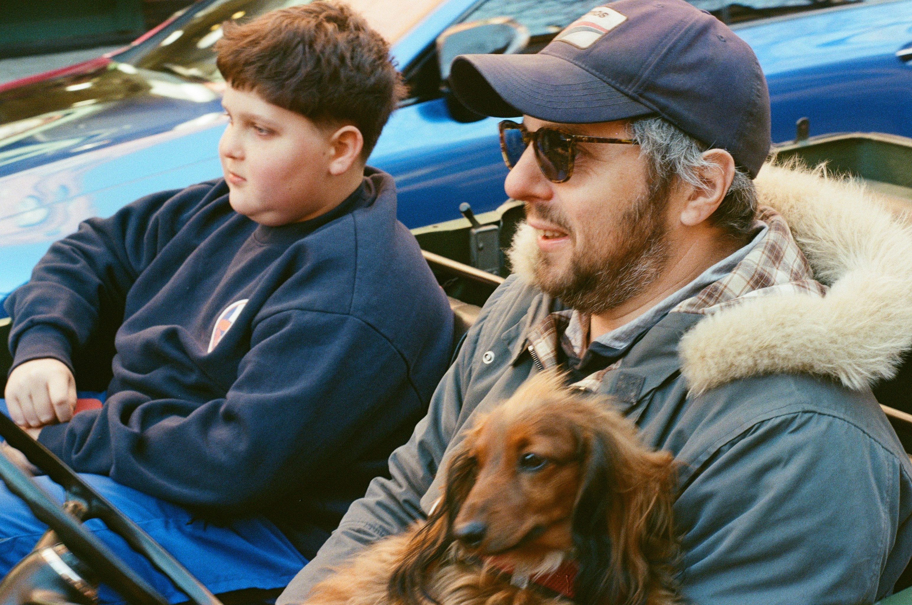 Man, boy, and dog in a car