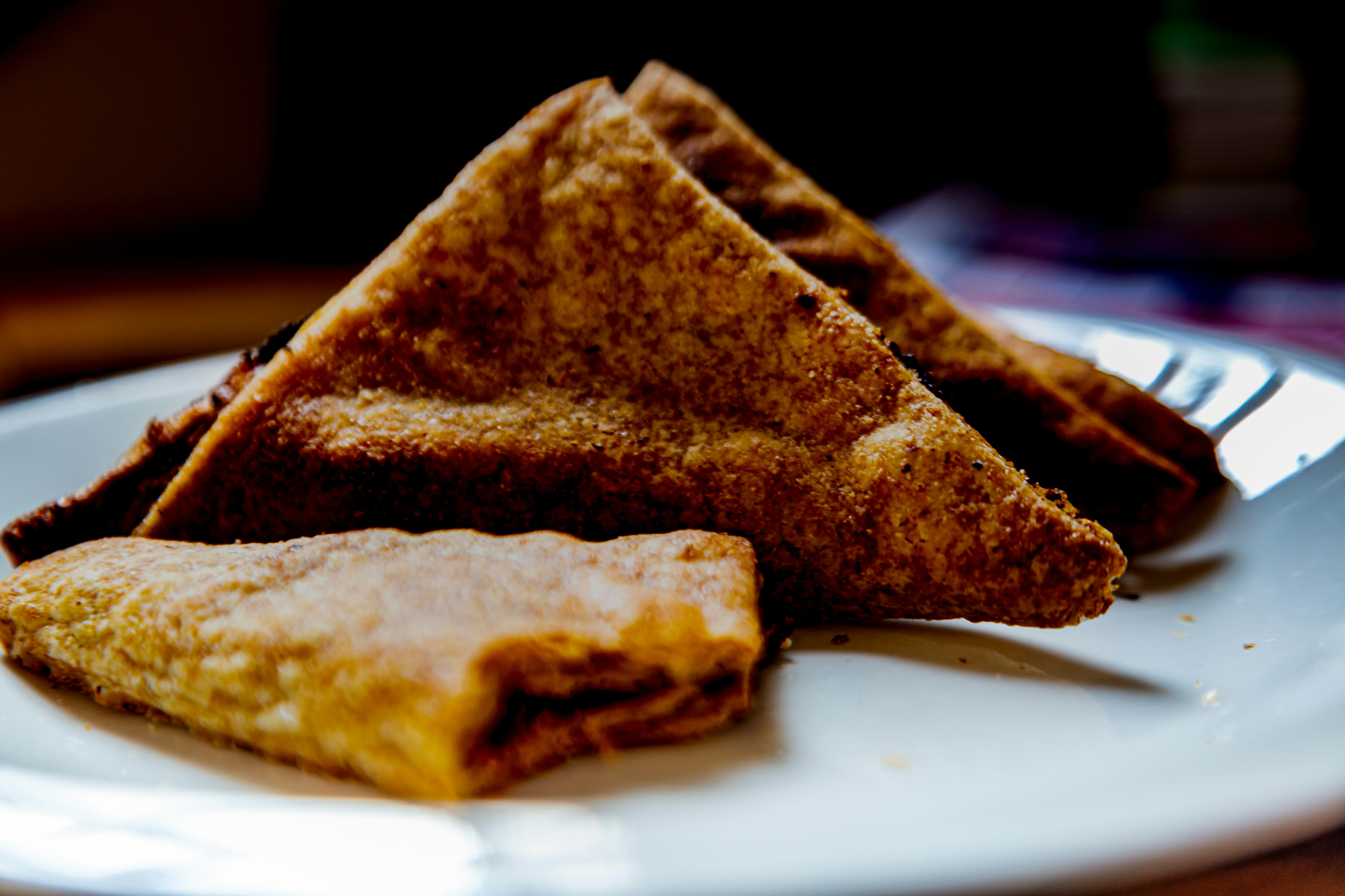 Tranches de pain grillé triangulaires sur une assiette blanche.