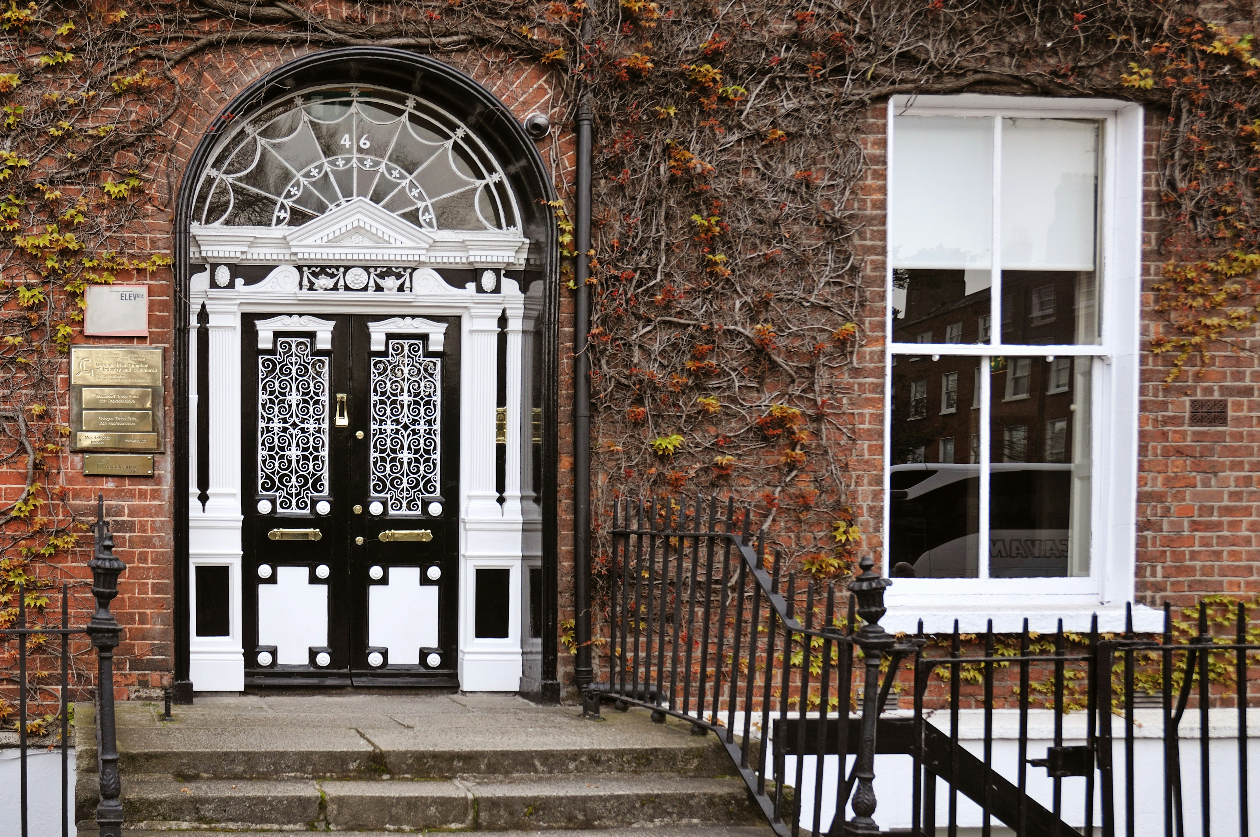 Ornate doorway with a window on a brick building.