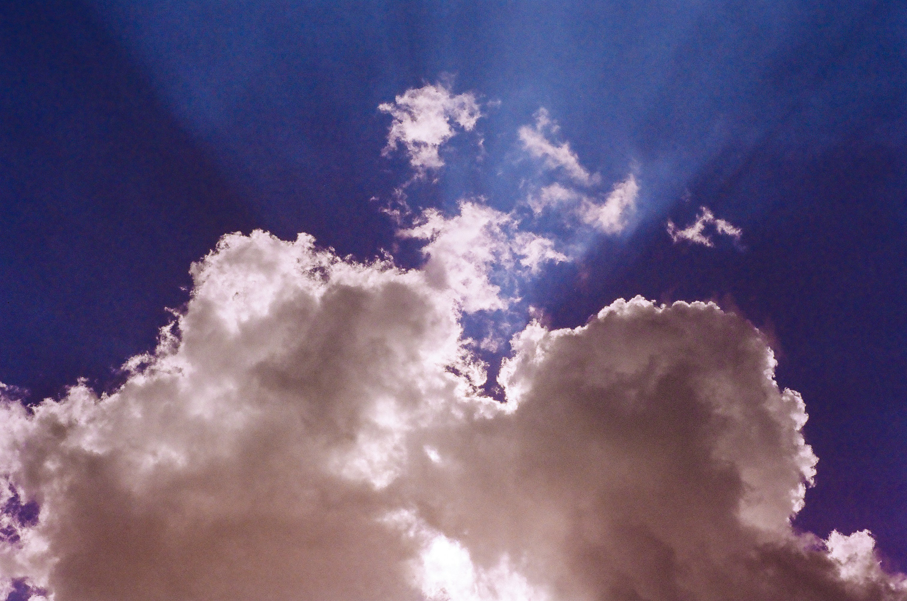 Sonnenstrahlen brechen durch dunkle, dramatische Wolken