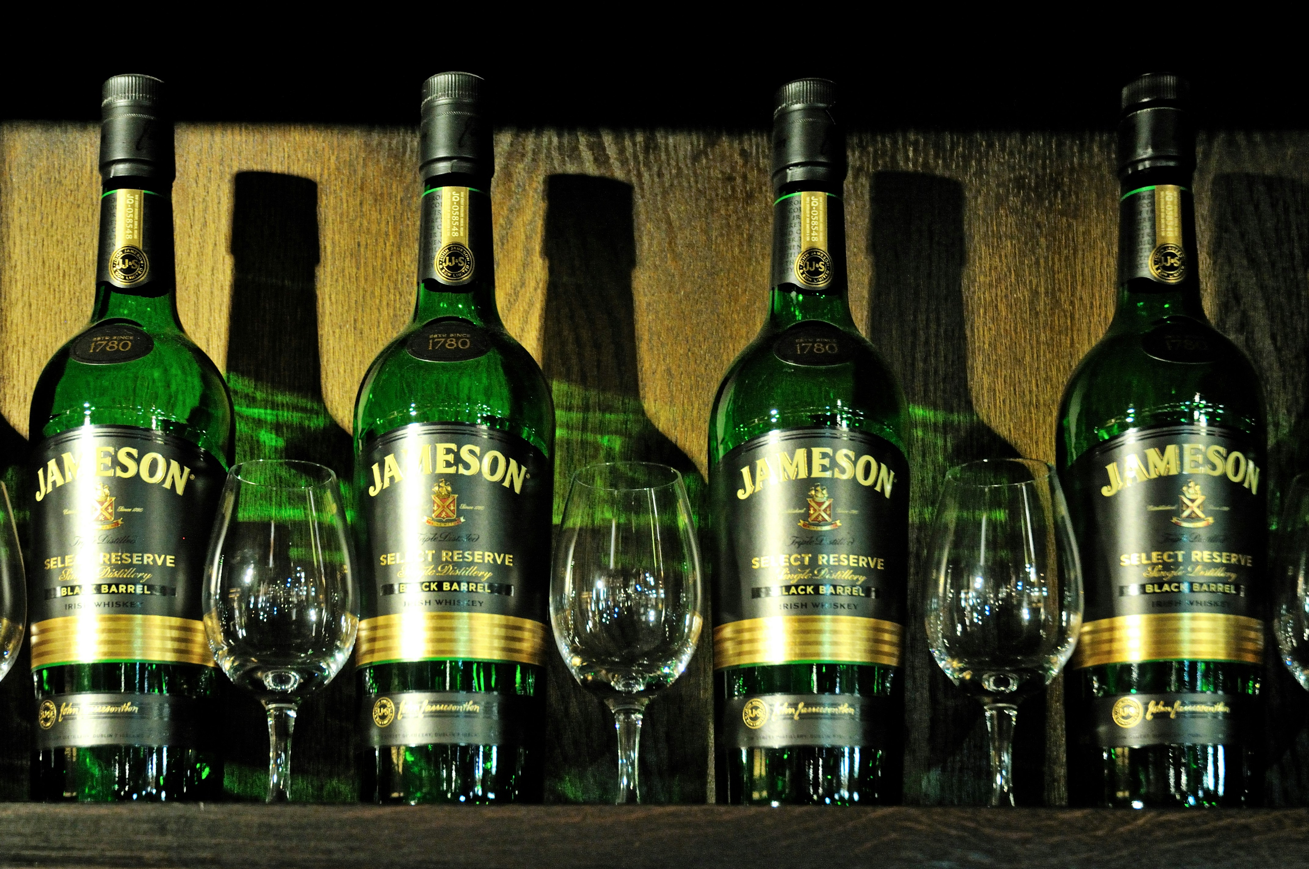 Vier Flaschen Jameson Whiskey mit Gläsern
