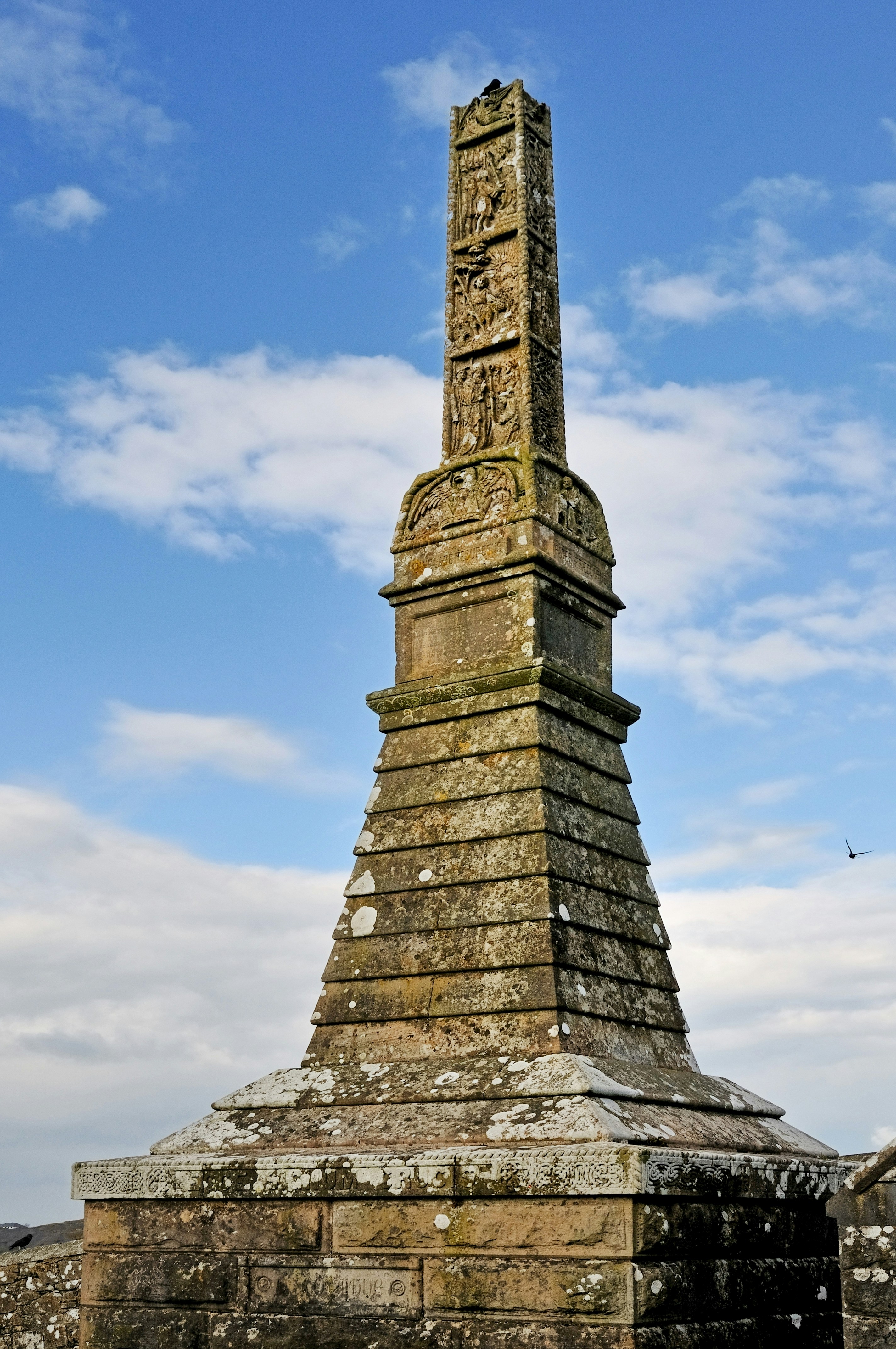 Stone monument with intricate carvings against a blue sky