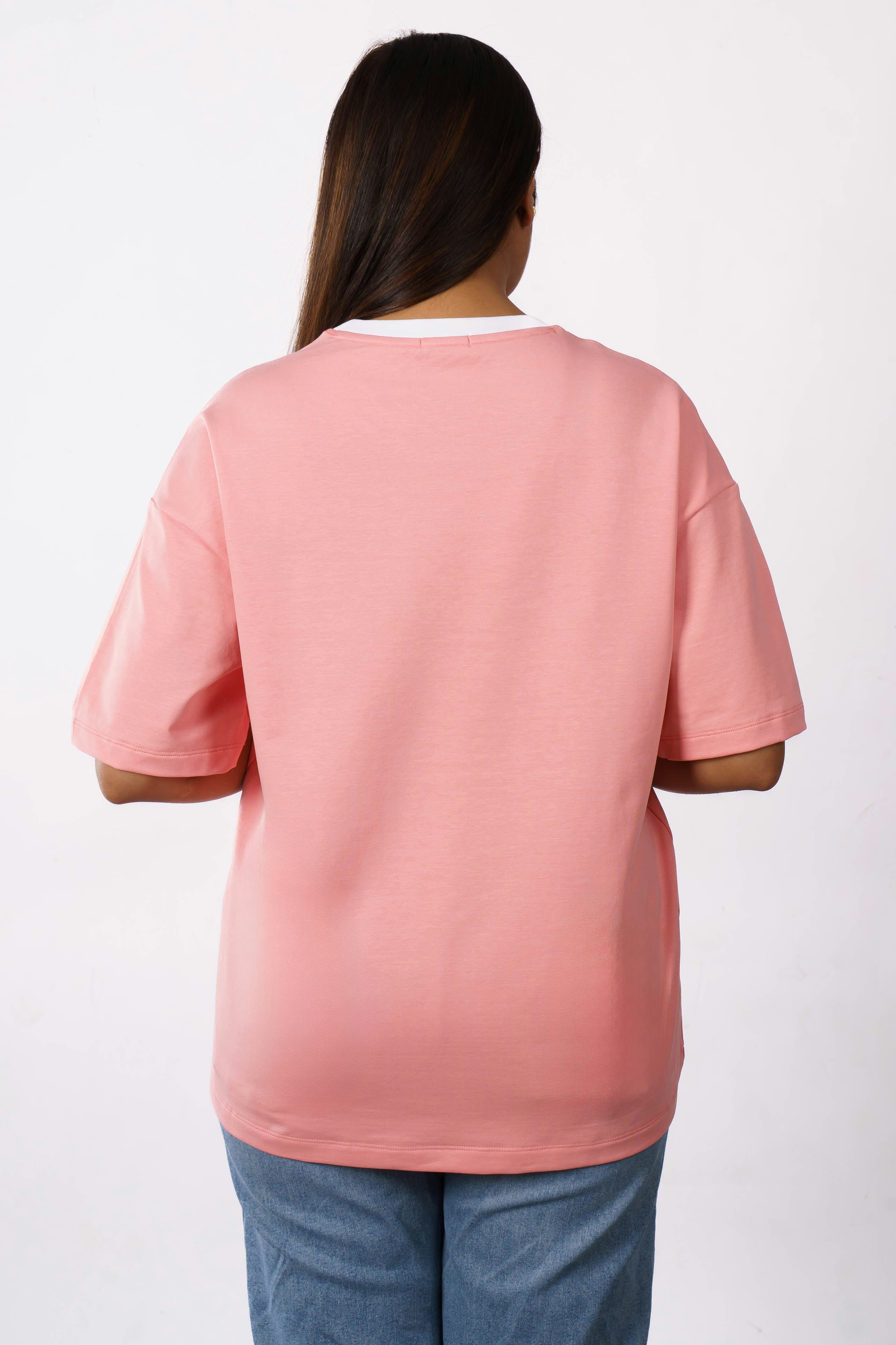 ピンクのTシャツとジーンズを着た女性。