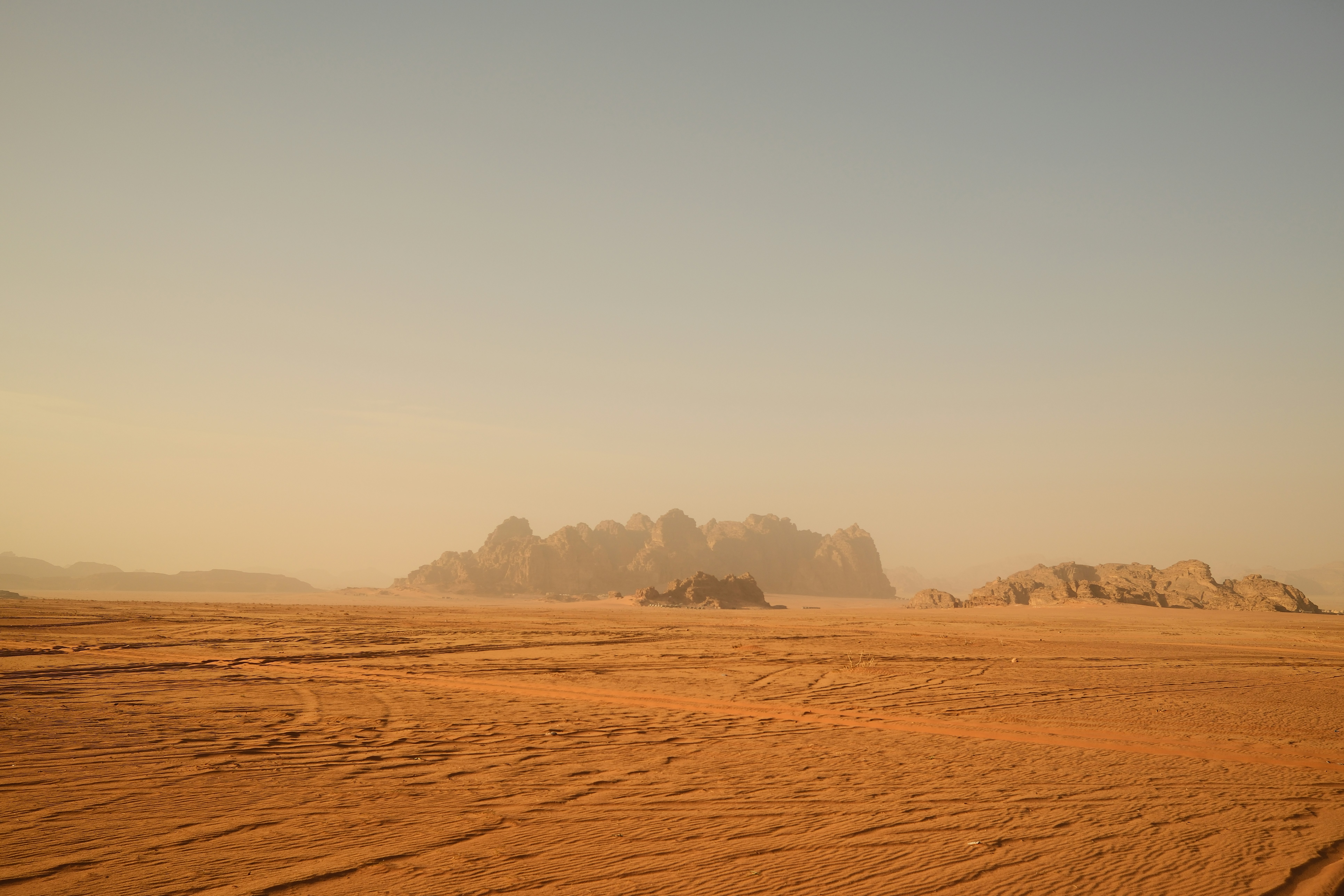 Vast desert landscape with rocky formations under a clear sky