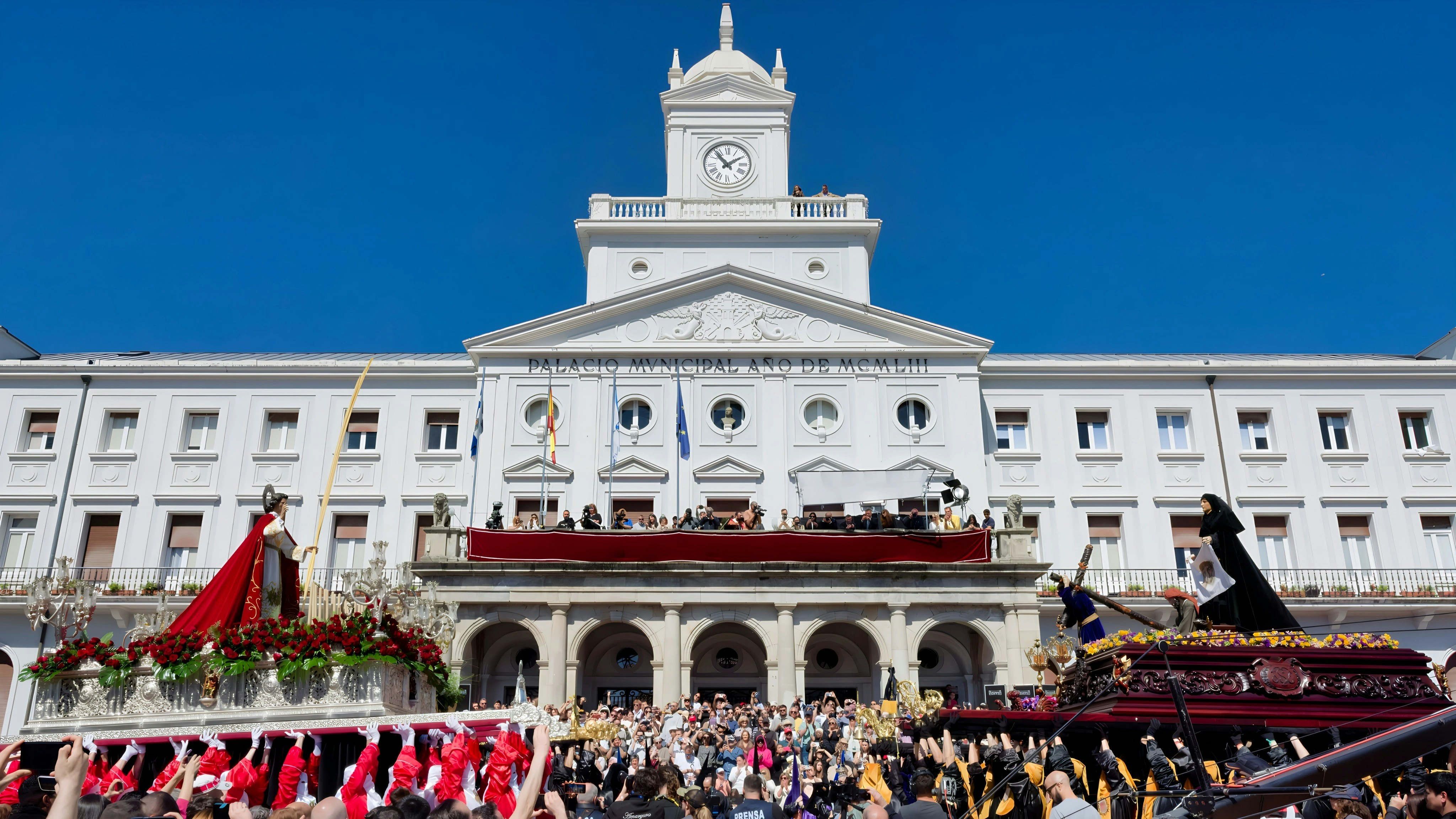 Processione religiosa davanti a un grande edificio bianco.
