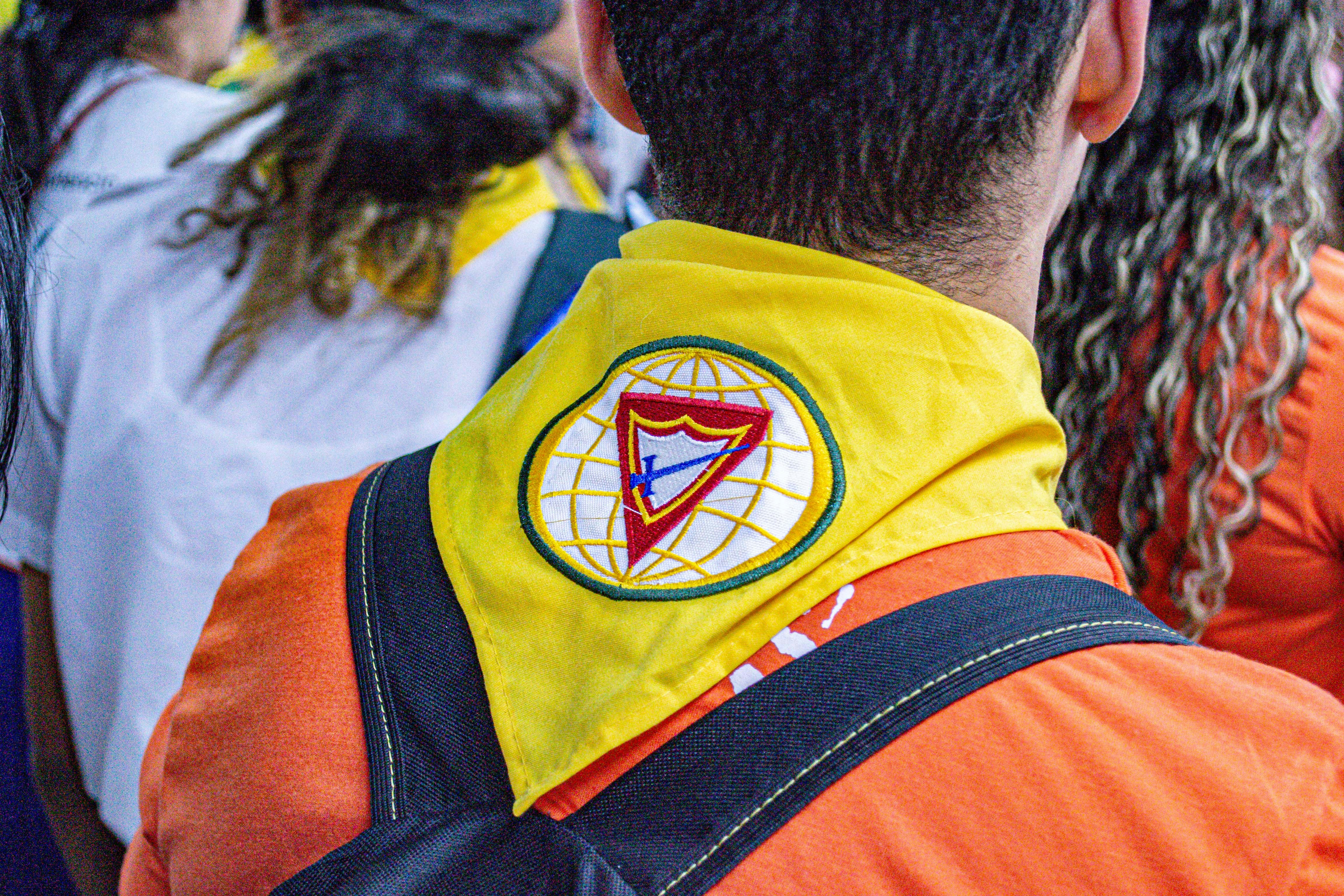 Person wearing a yellow scarf with a crest