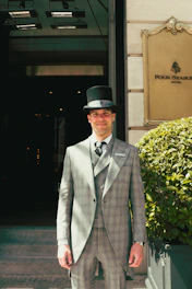 Man in formal attire standing outside four seasons hotel.