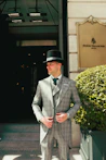 Man in formal attire standing outside four seasons hotel.