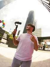 Man filming with gimbal and phone in city
