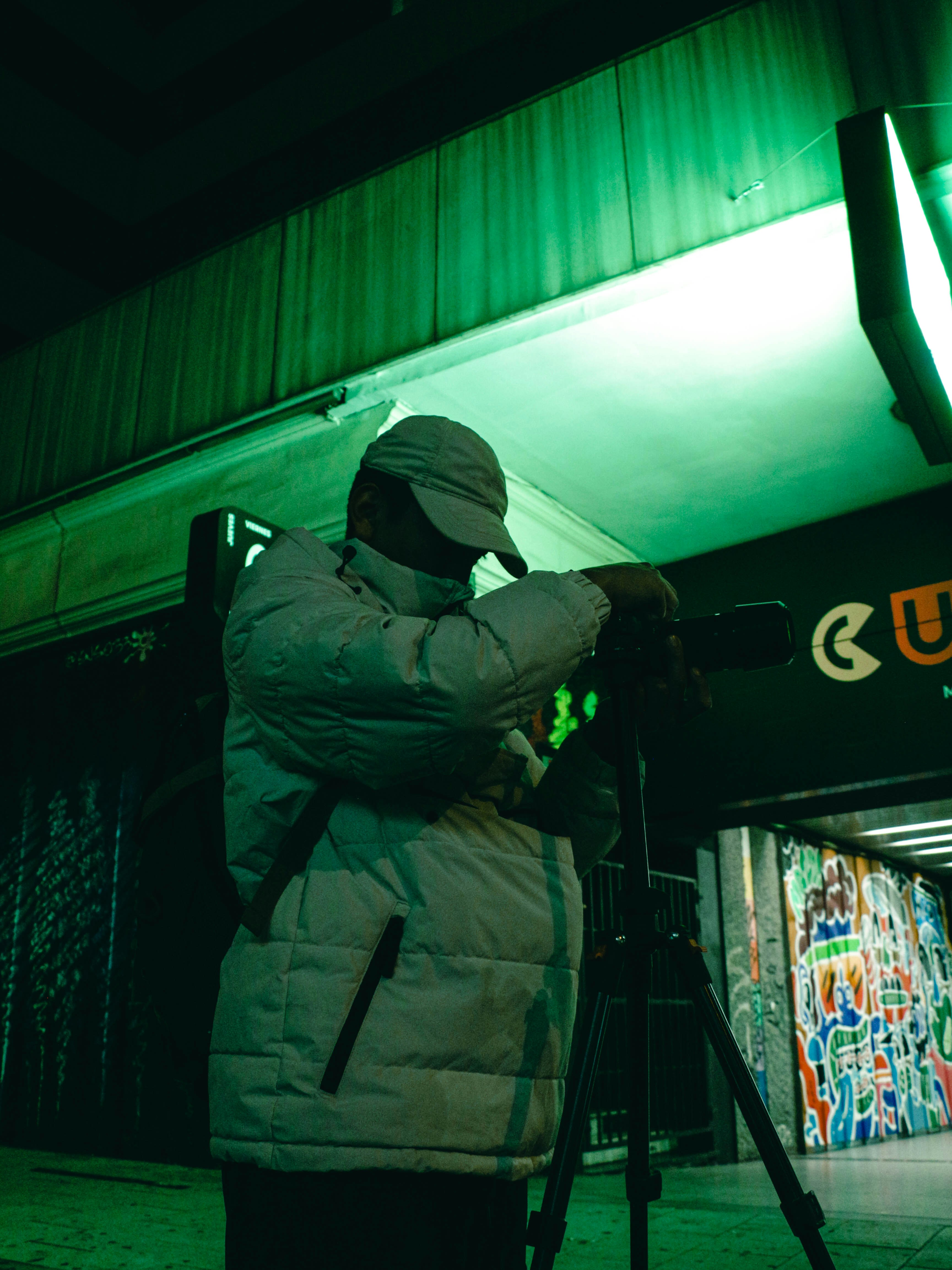 밤에 삼각대 위로 카메라를 촬영하는 사람