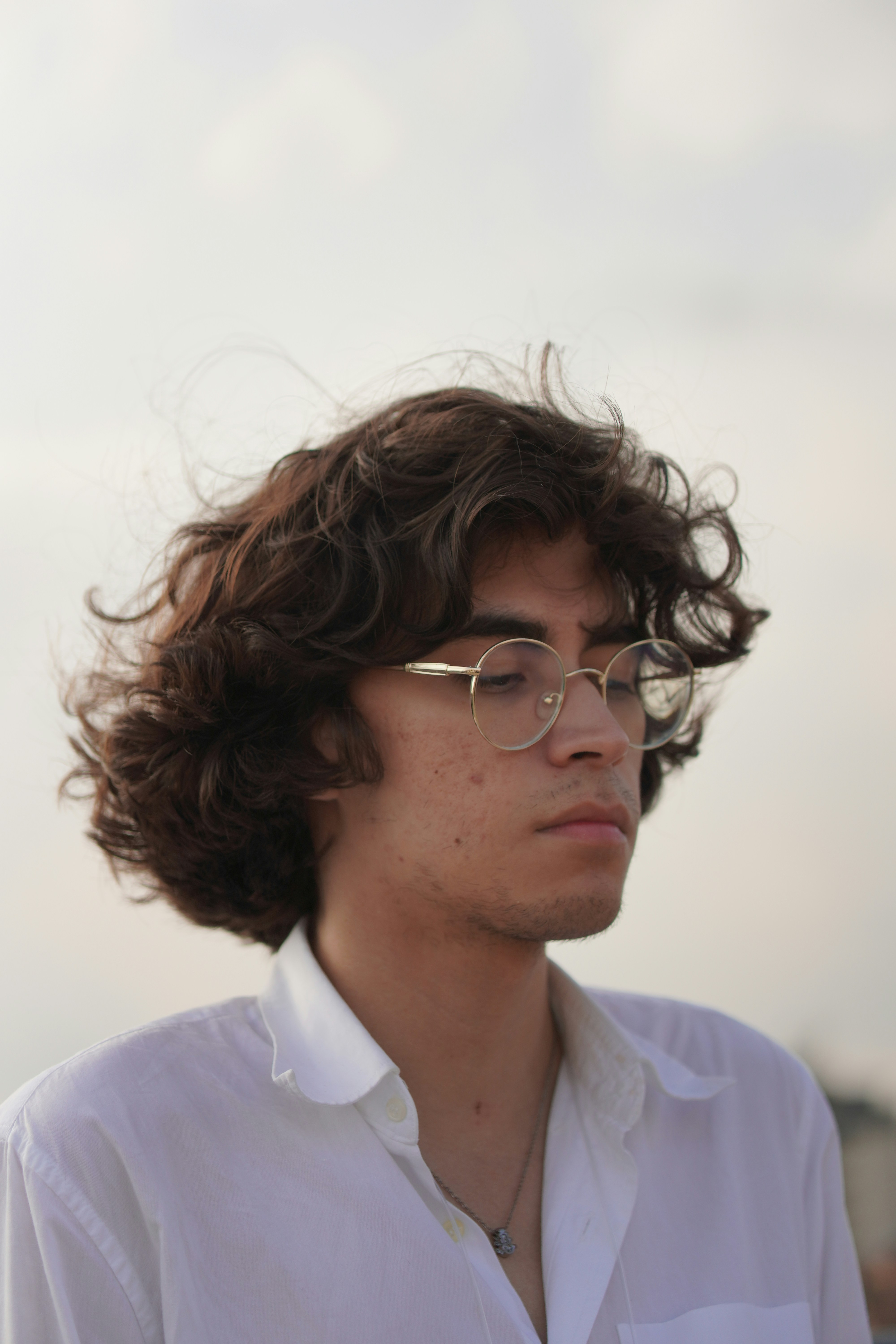 Young man with curly hair and glasses