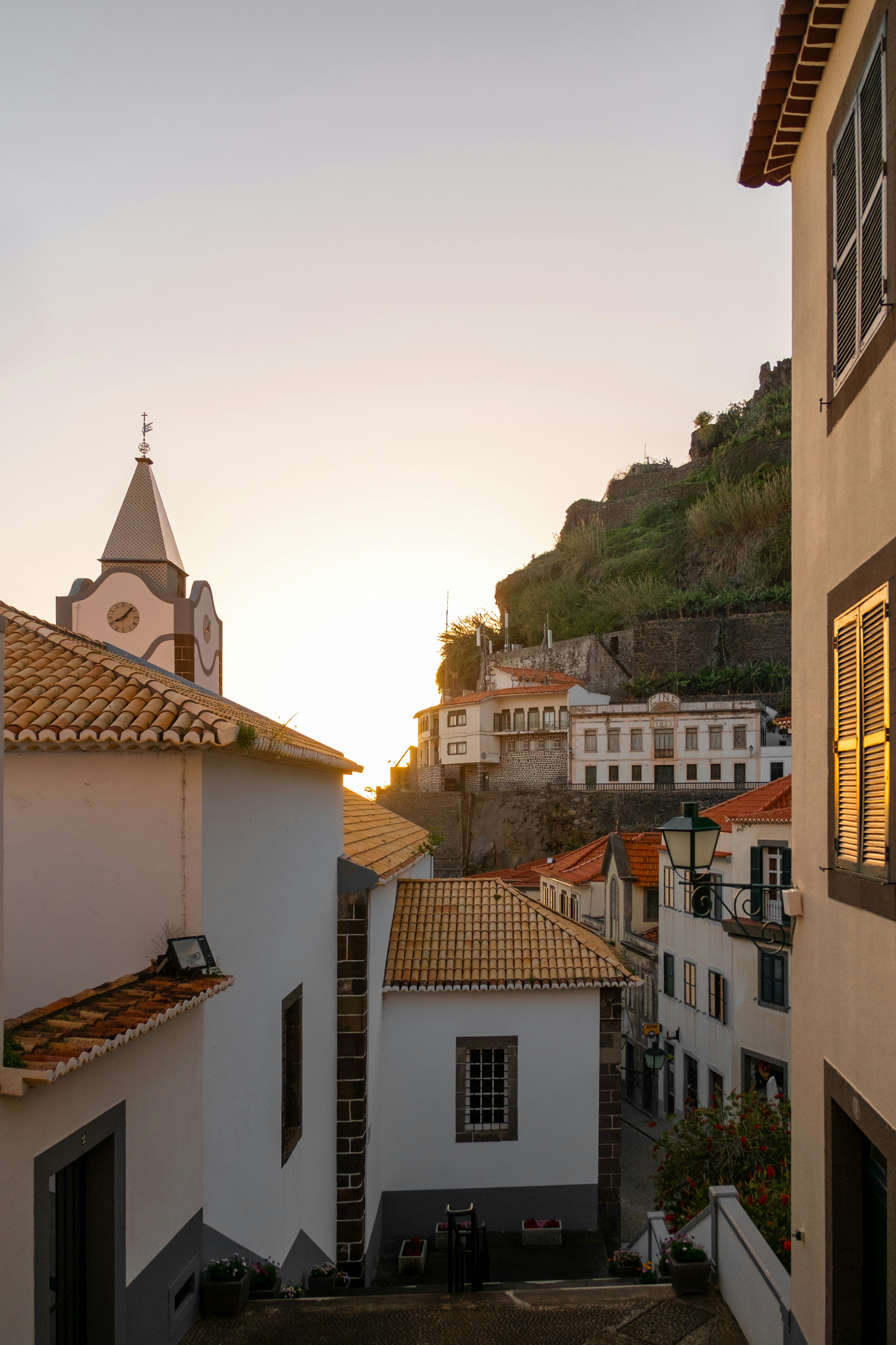 Village buildings on a hillside at sunset.