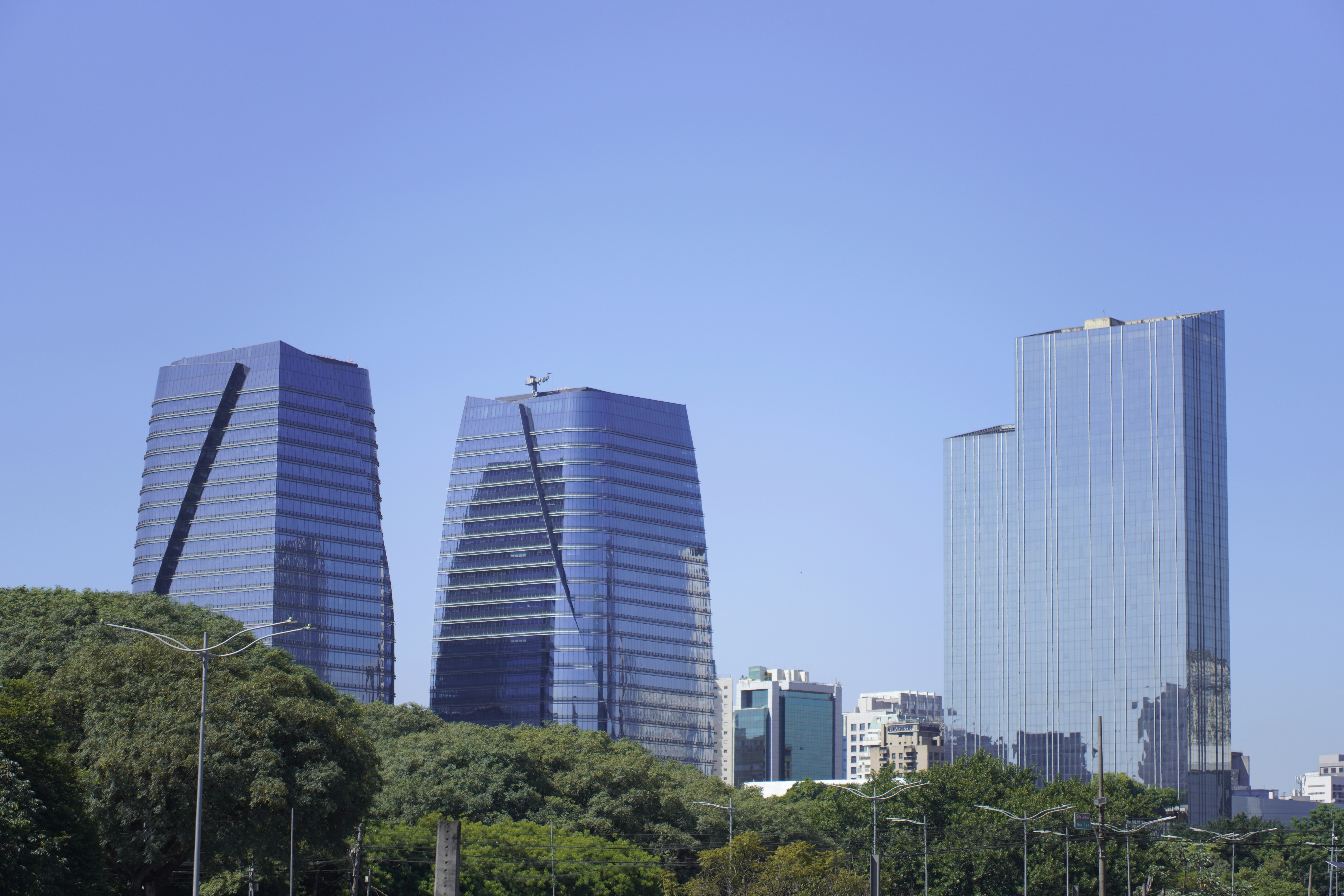 Modern glass skyscrapers against a clear blue sky.