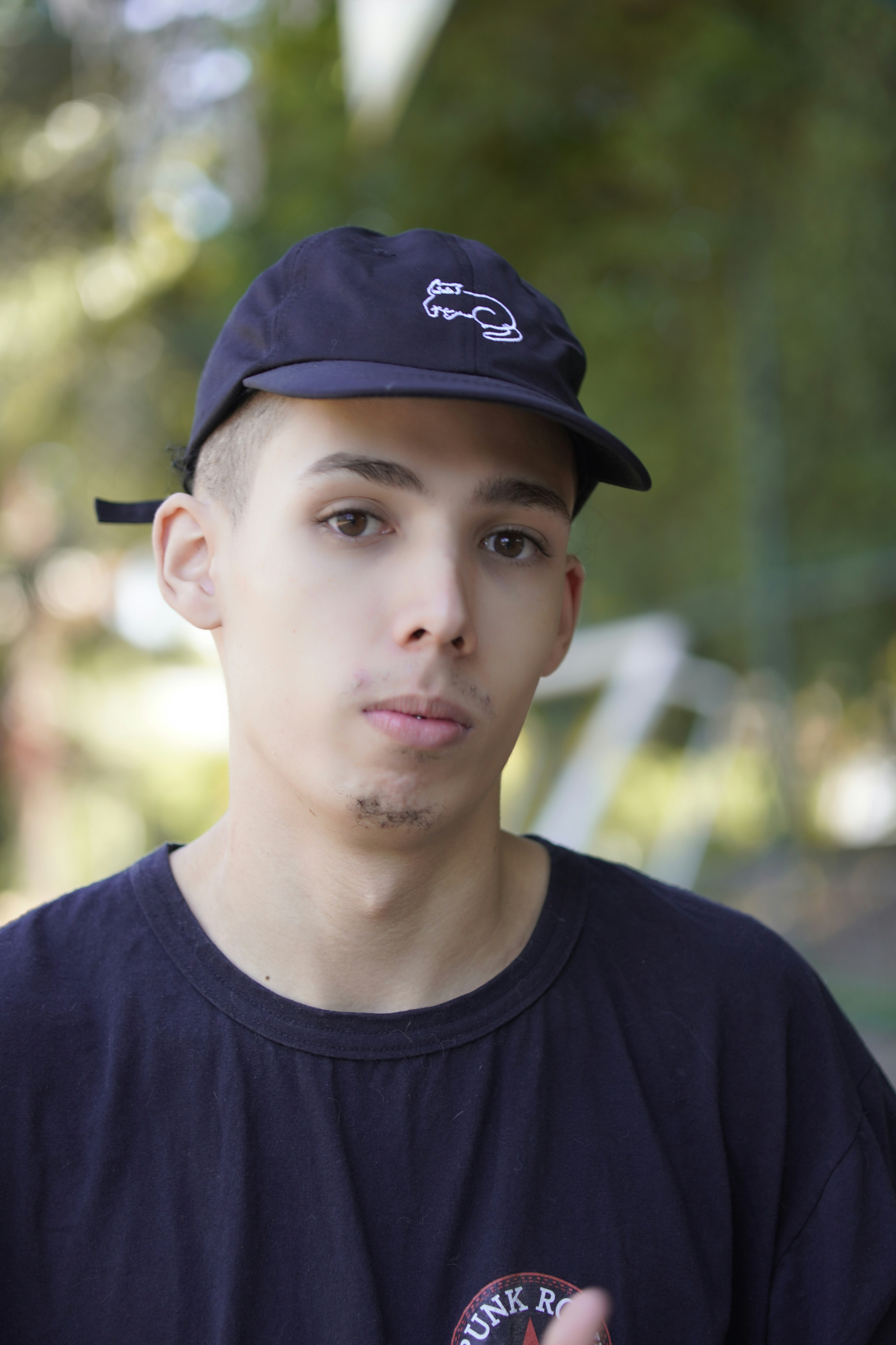 A young man wearing a baseball cap and t-shirt.