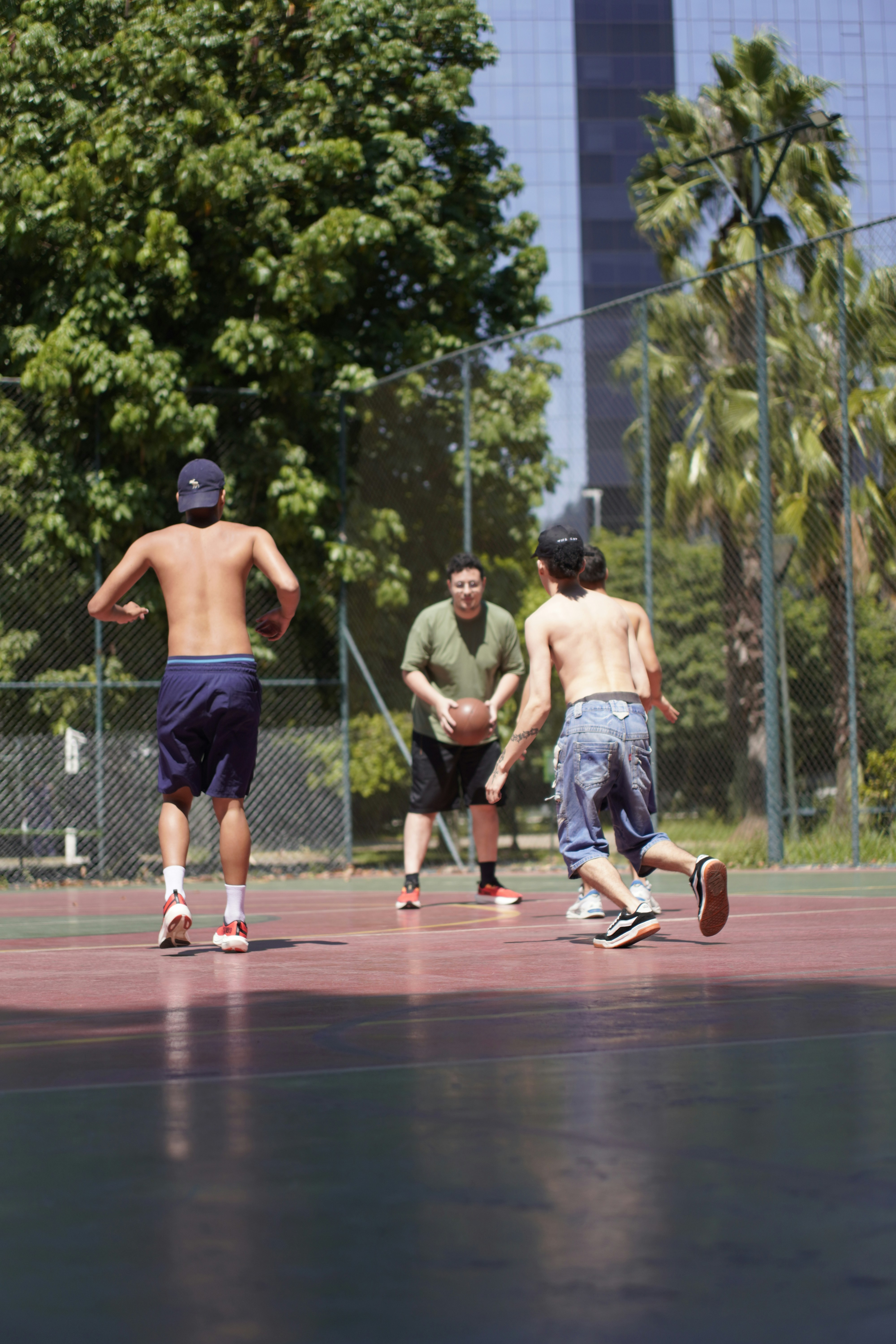 Men playing basketball on an outdoor court.