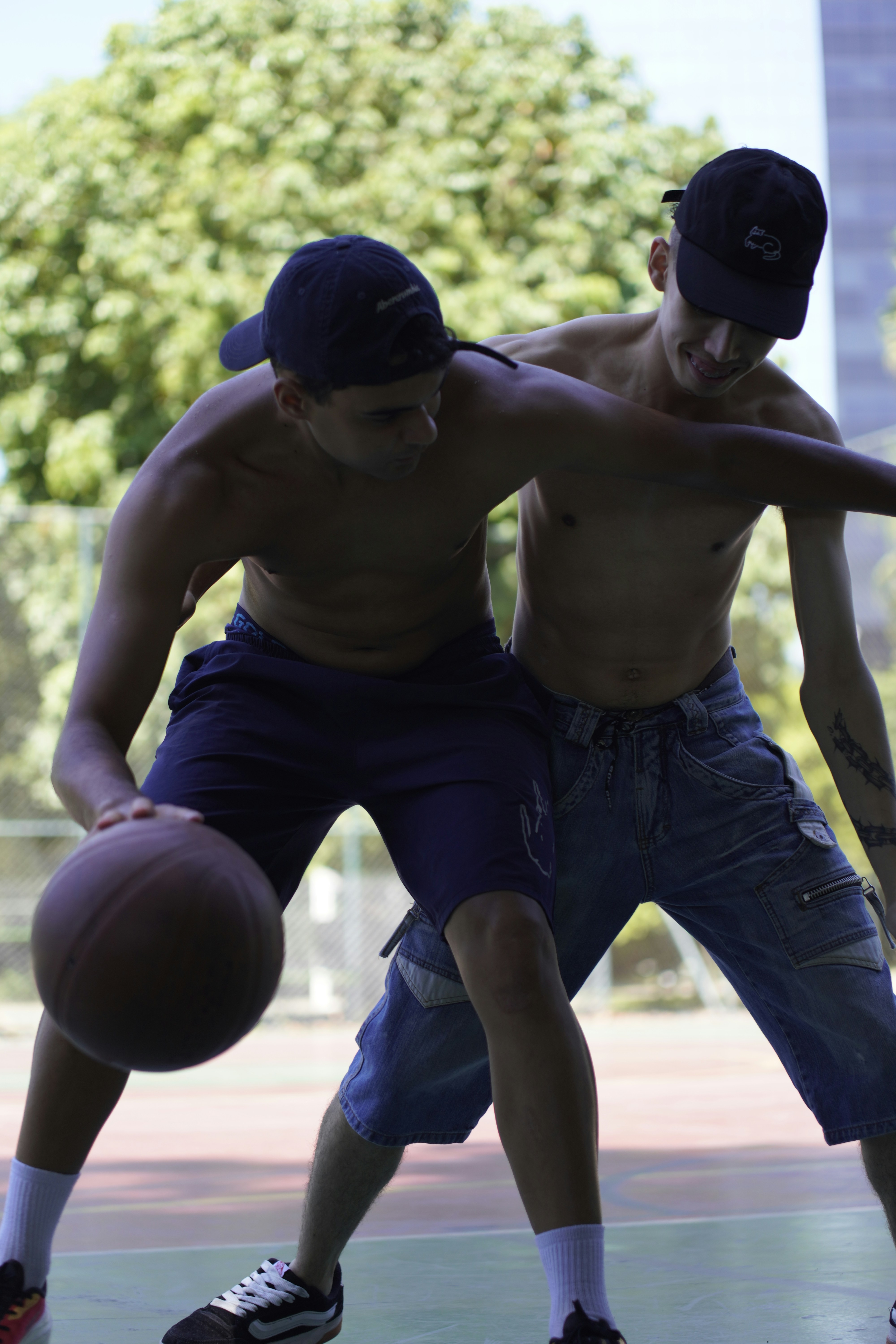 Two young men playing basketball outdoors