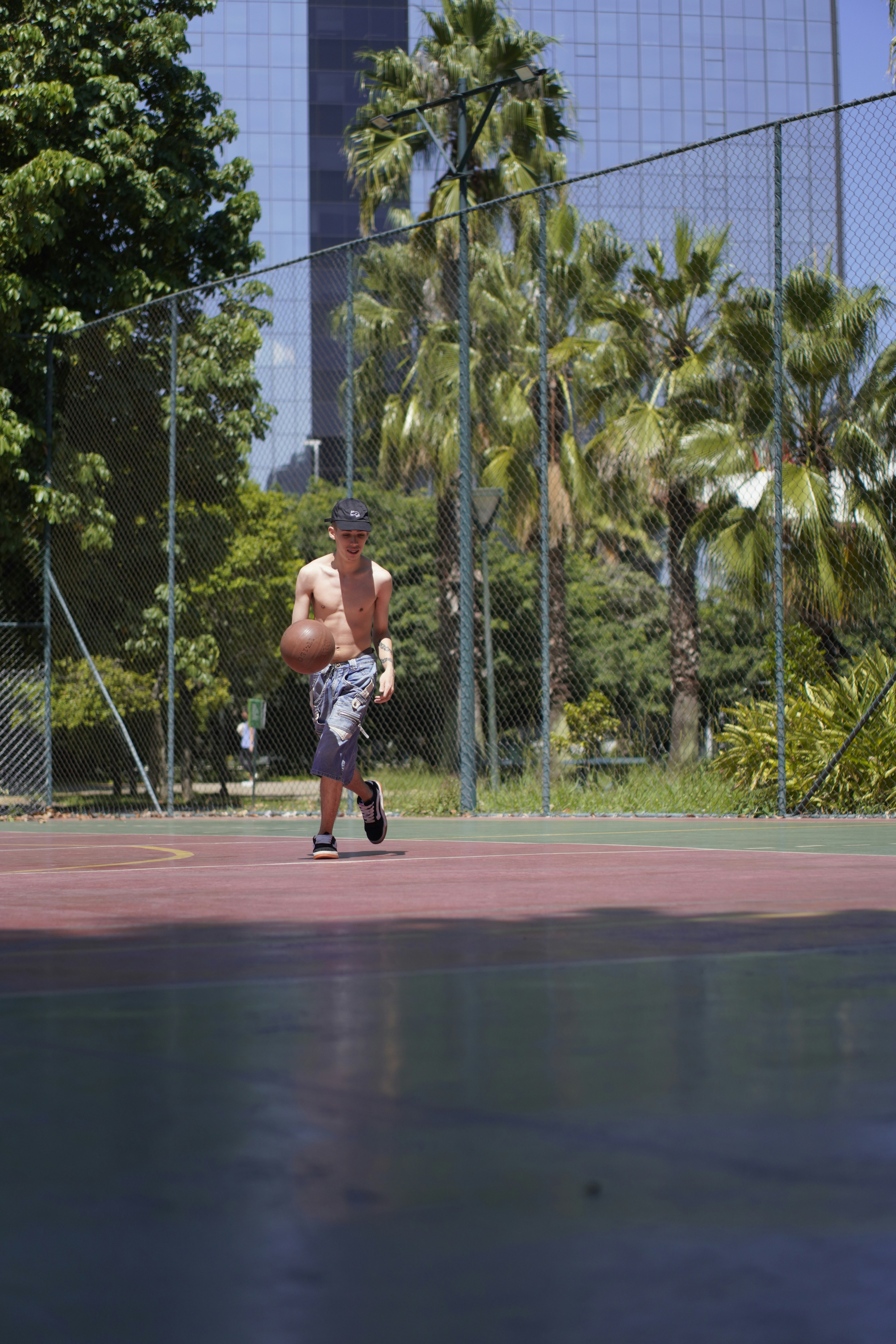 Young man dribbling a basketball on an outdoor court
