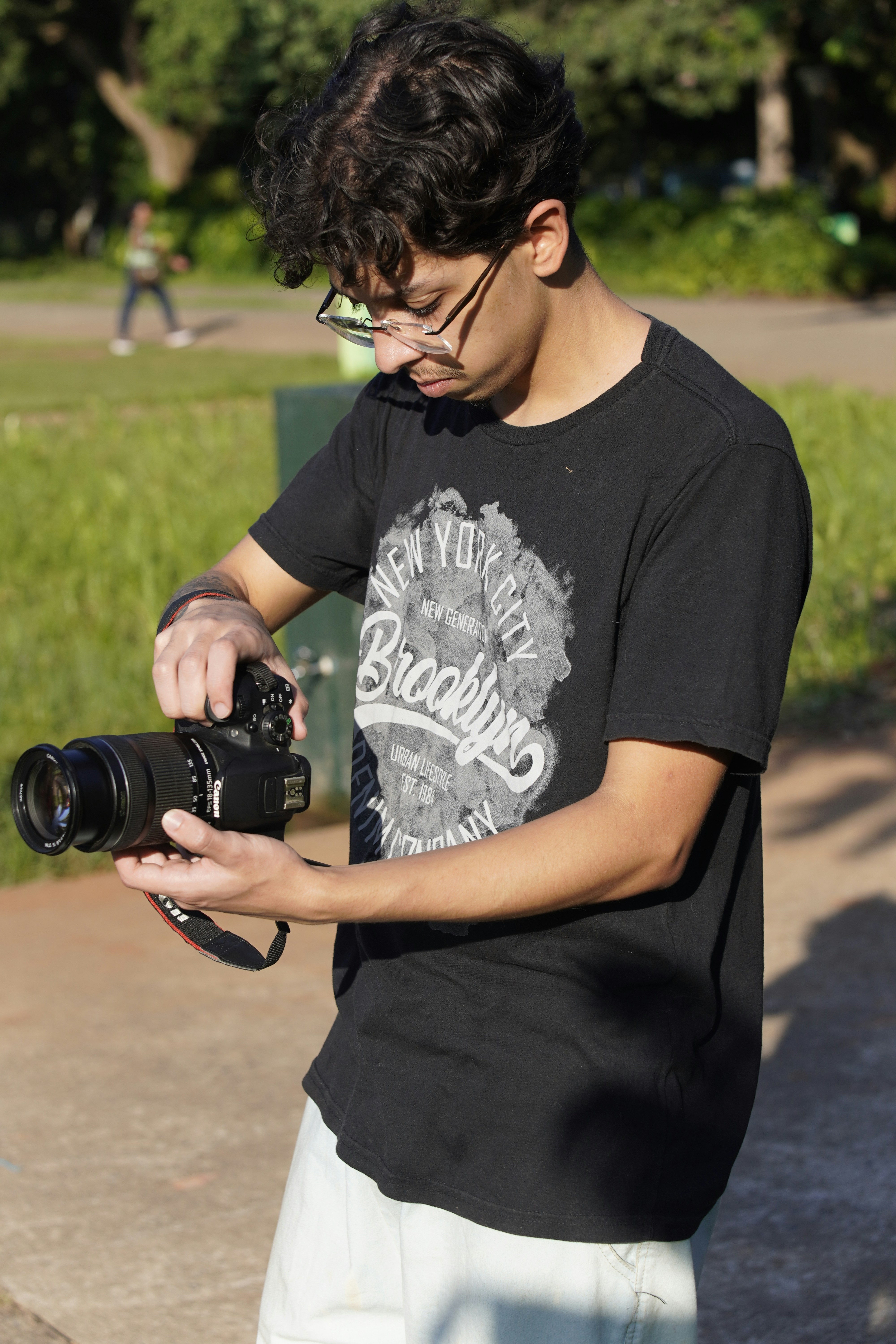 Young man holding a professional camera outdoors