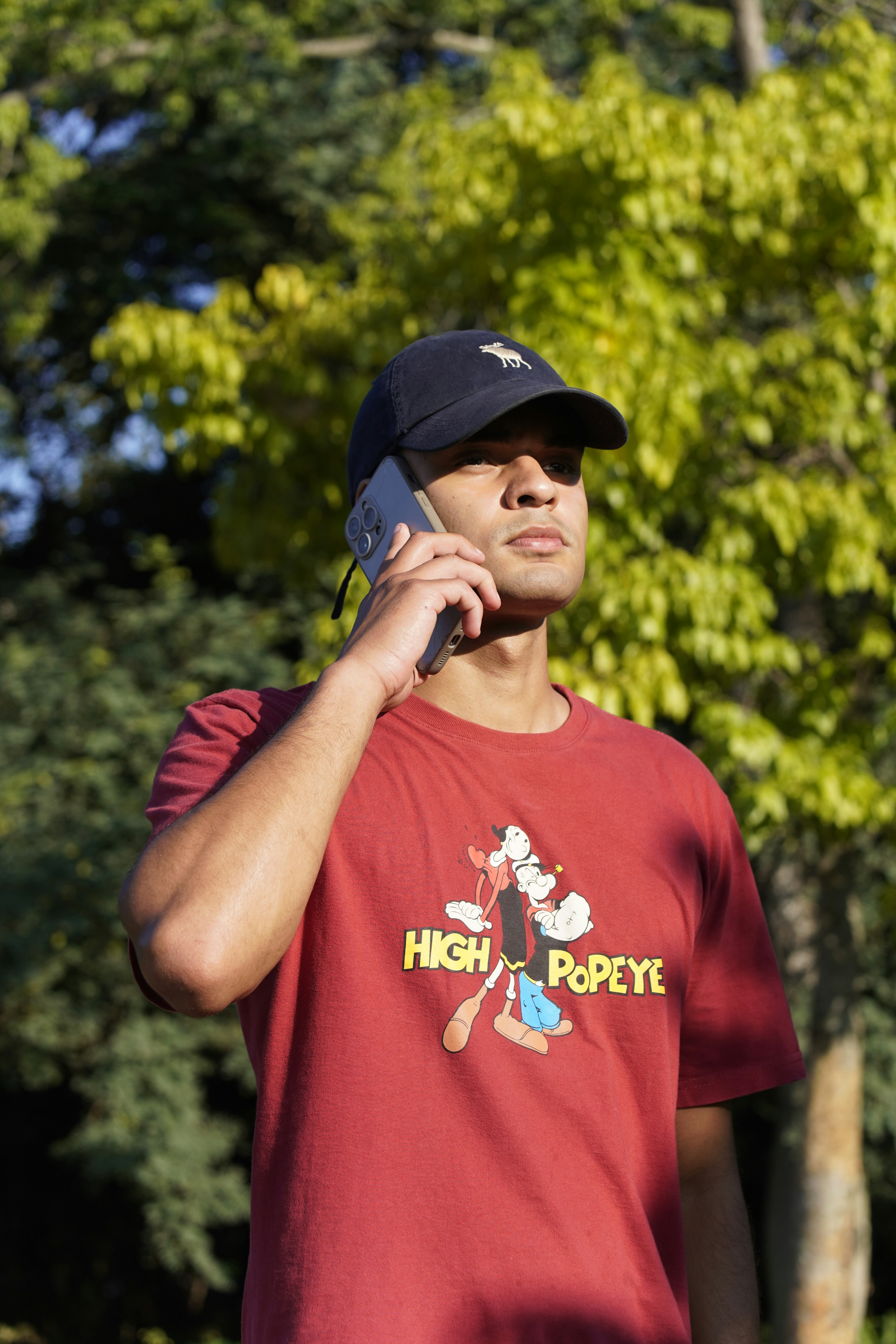 Man in a hat talking on a cell phone outdoors