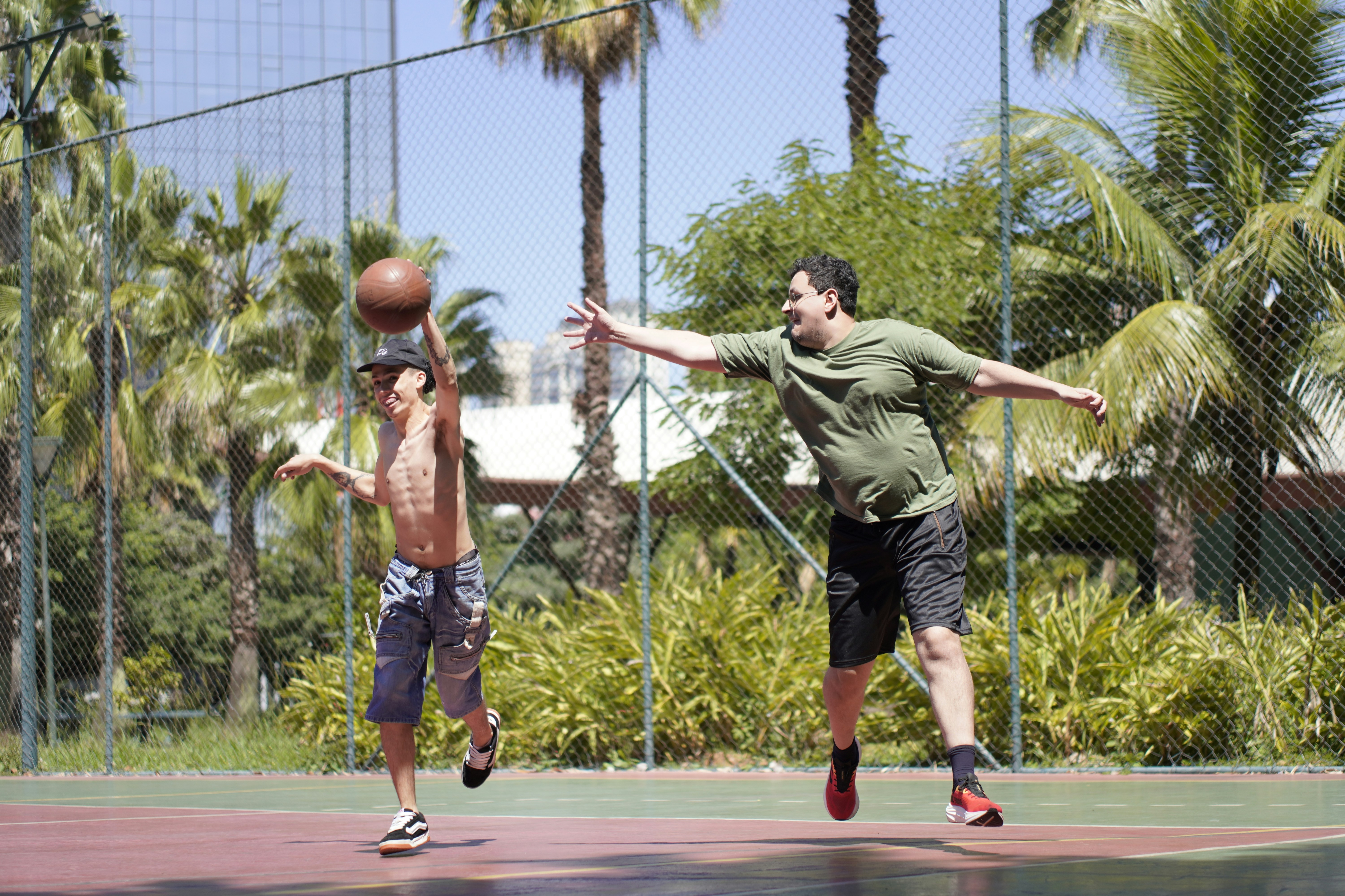 Two men playing basketball on an outdoor court.