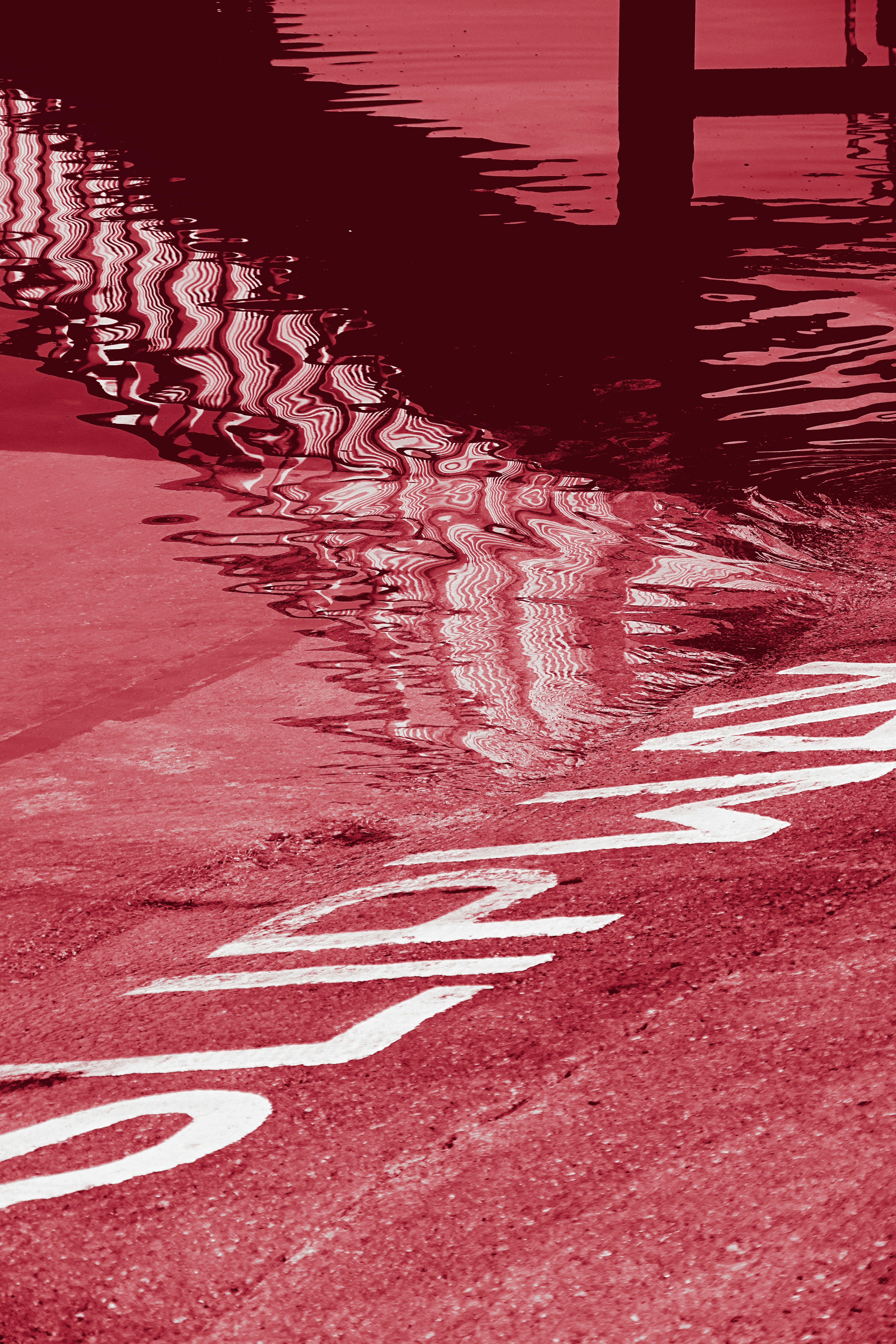 Street markings reflected in rippling water
