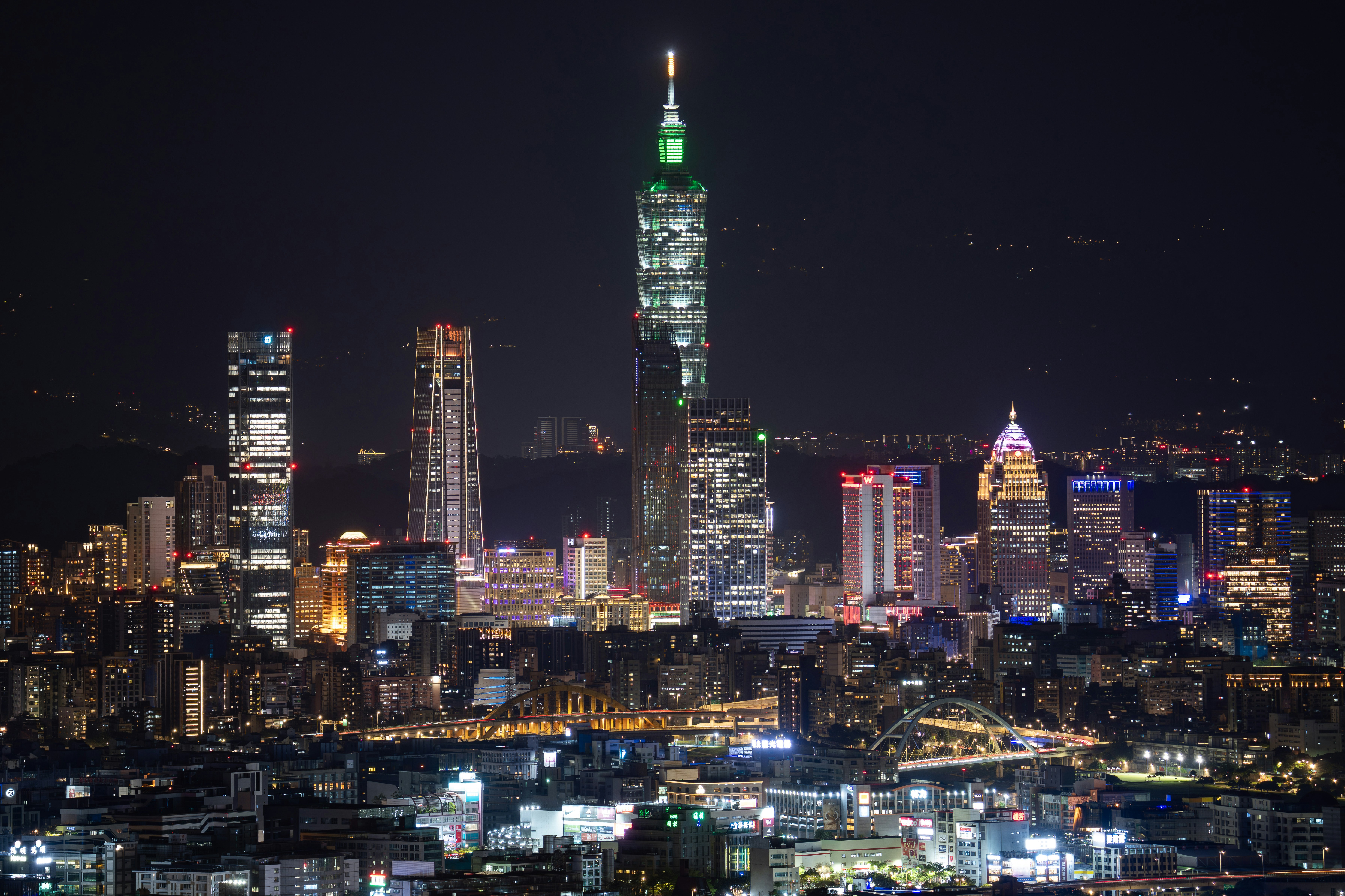 Skyscrapers illuminated at night in a sprawling cityscape.
