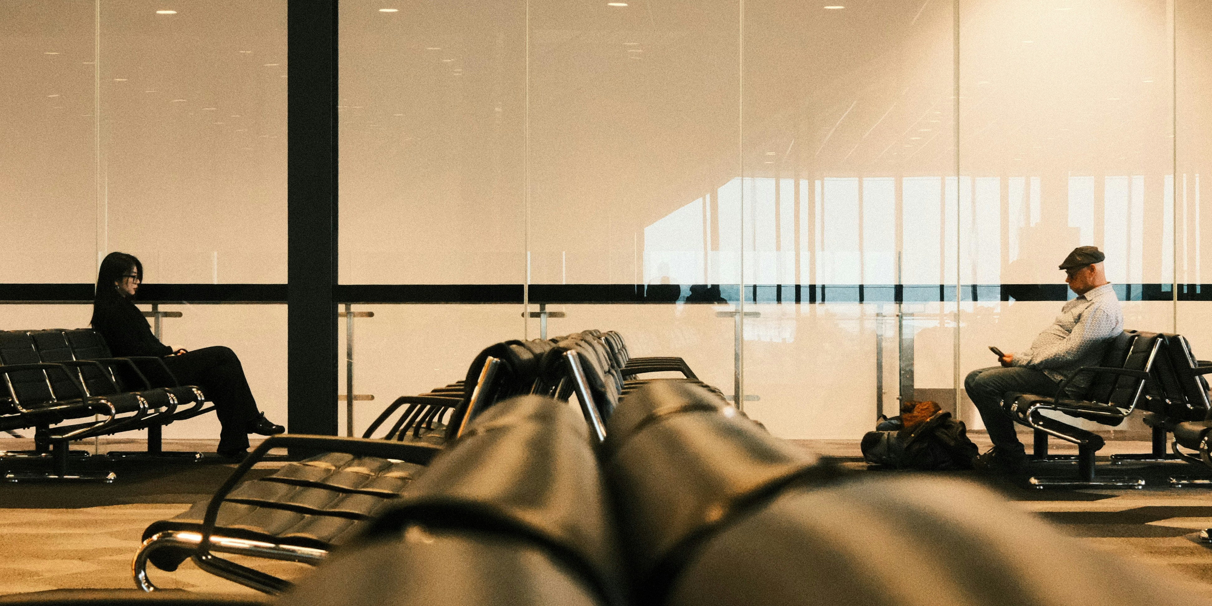 Deux personnes sont assises dans une salle d’attente à l’aéroport.