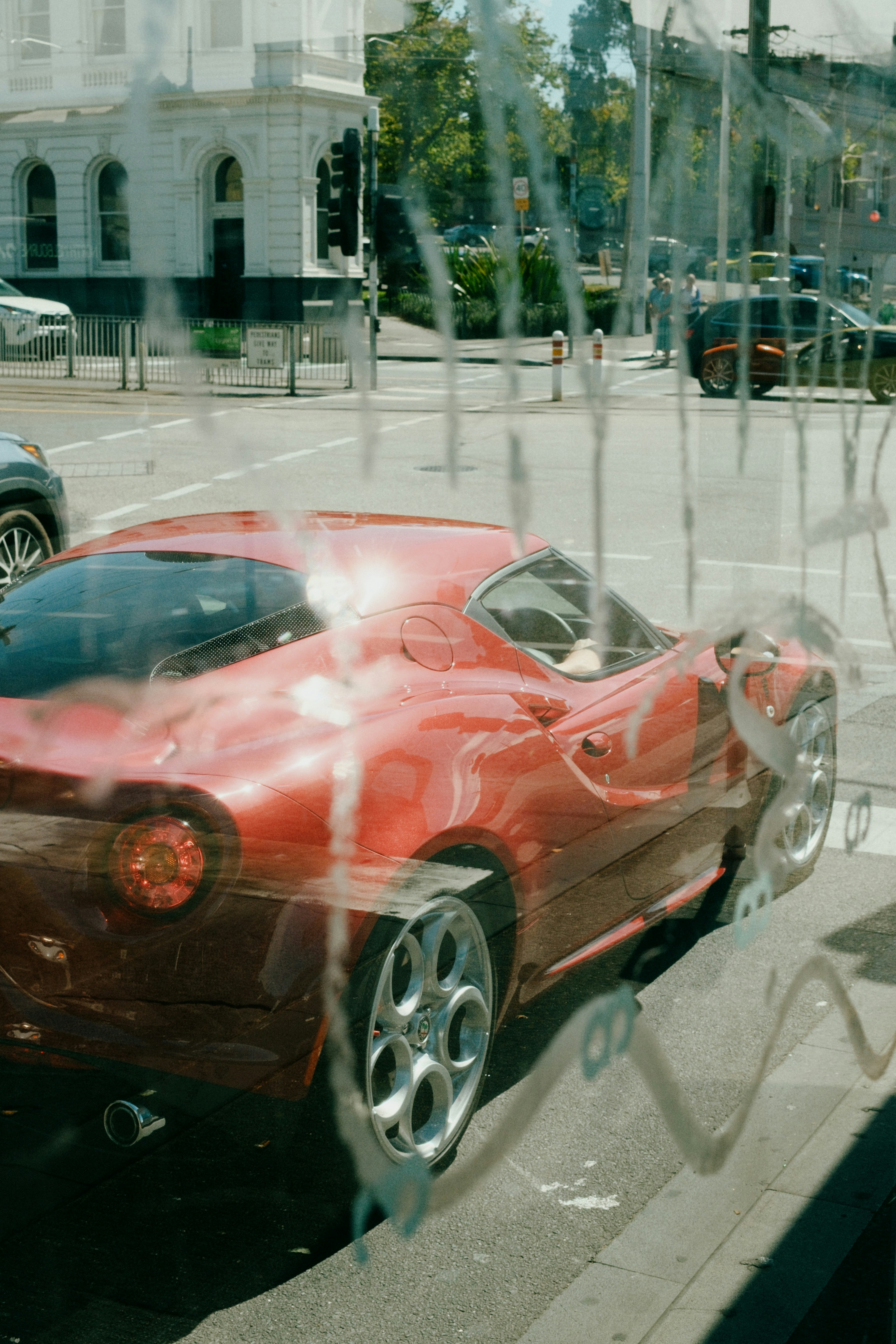 Voiture de sport rouge garée dans une rue de la ville.