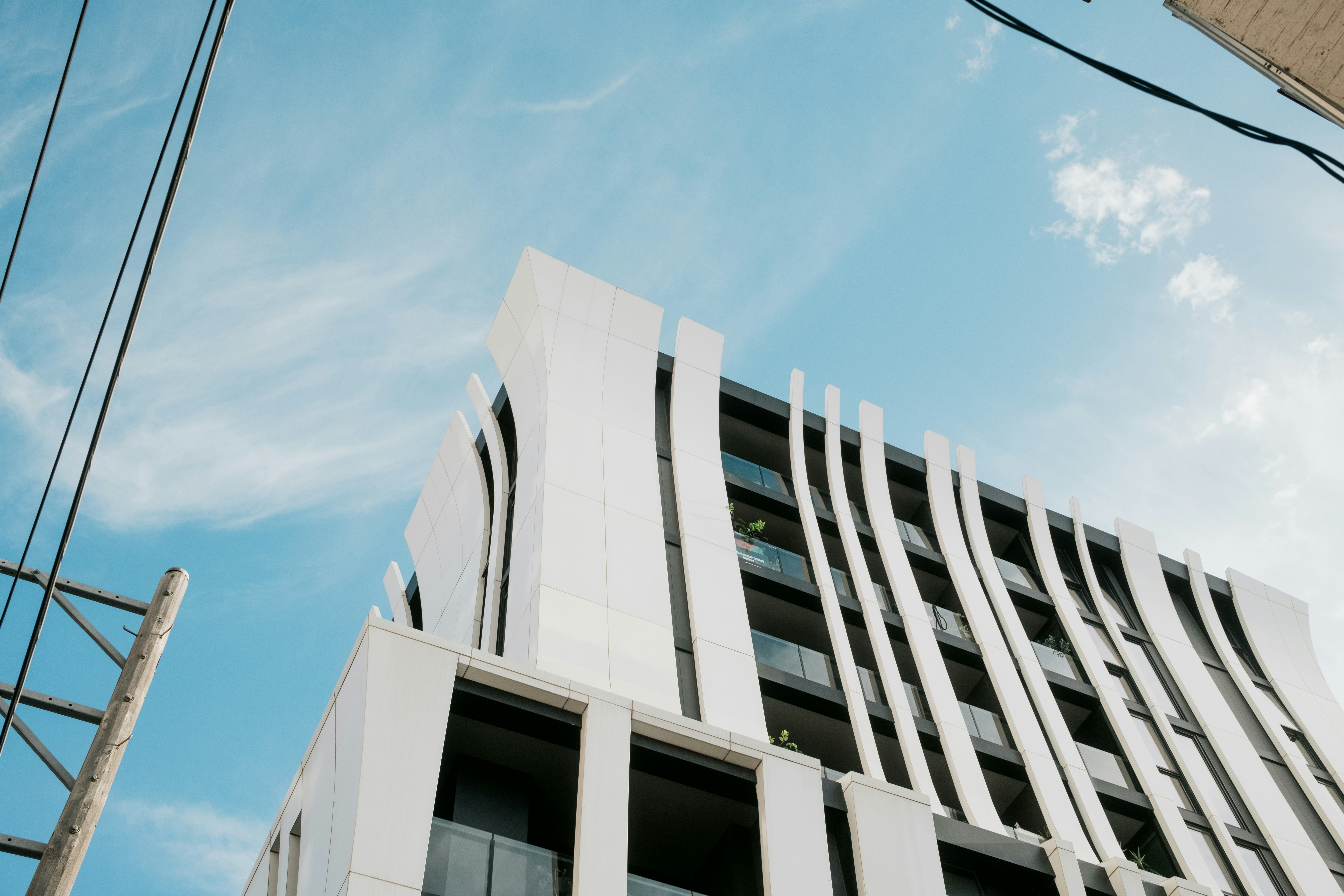 Bâtiment blanc moderne à façade ondulée sur un ciel bleu