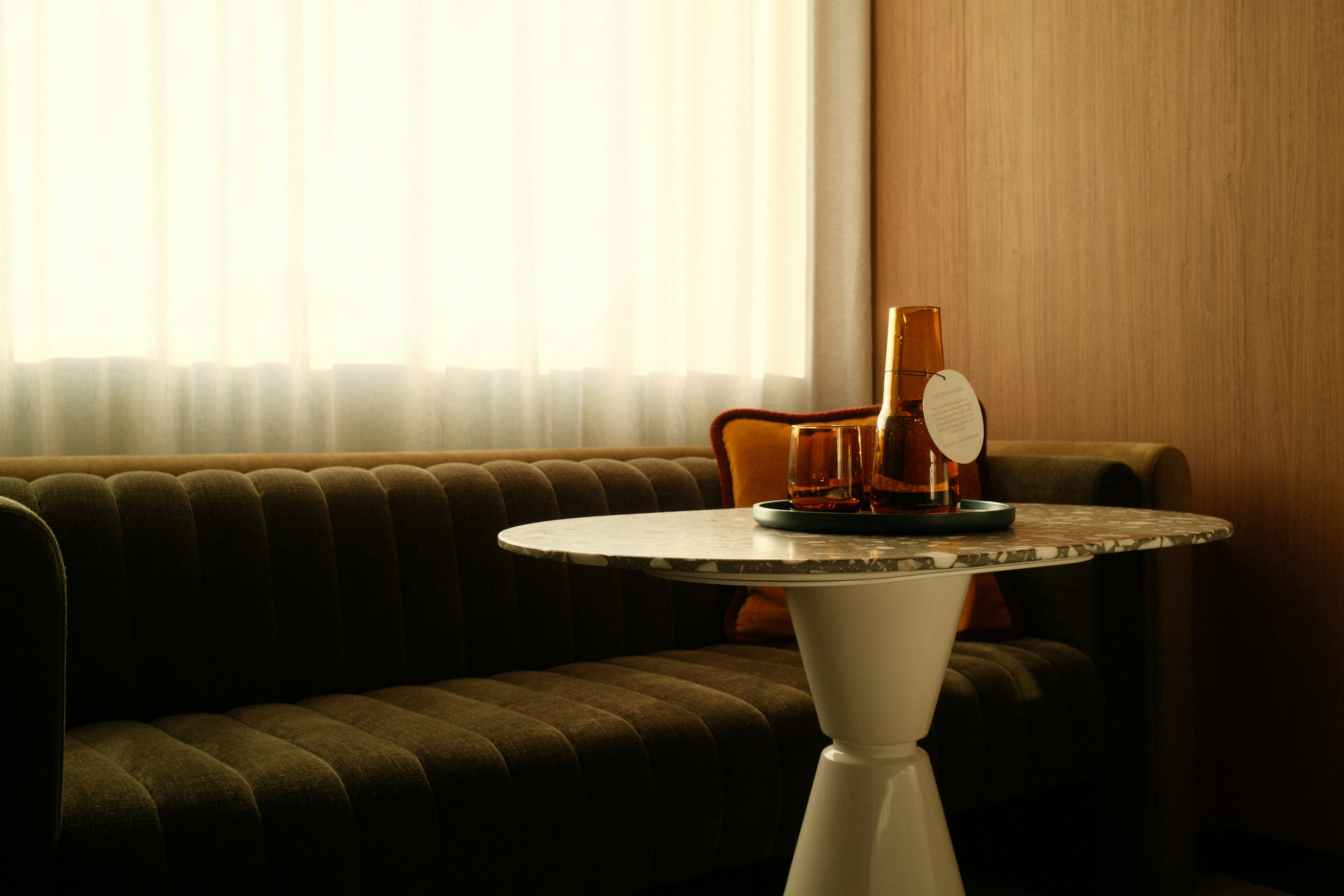 Canapé et table avec boissons dans une pièce moderne.