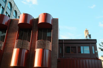 Modern building with red cylindrical accents against blue sky