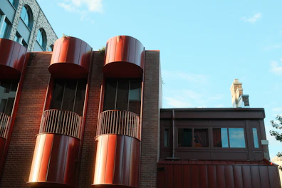 Modern building with red cylindrical accents against blue sky