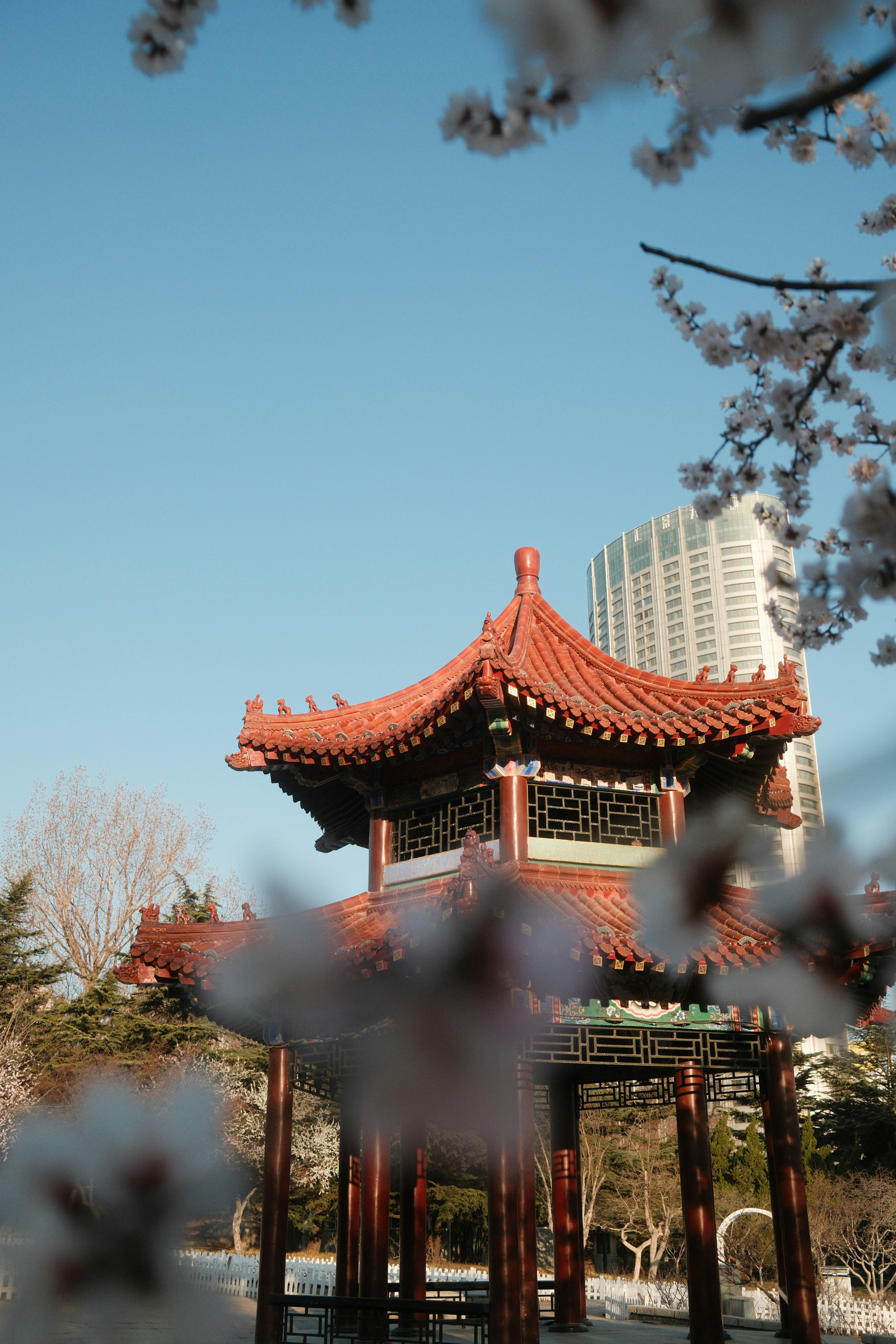 Traditional pagoda with modern skyscraper behind it.