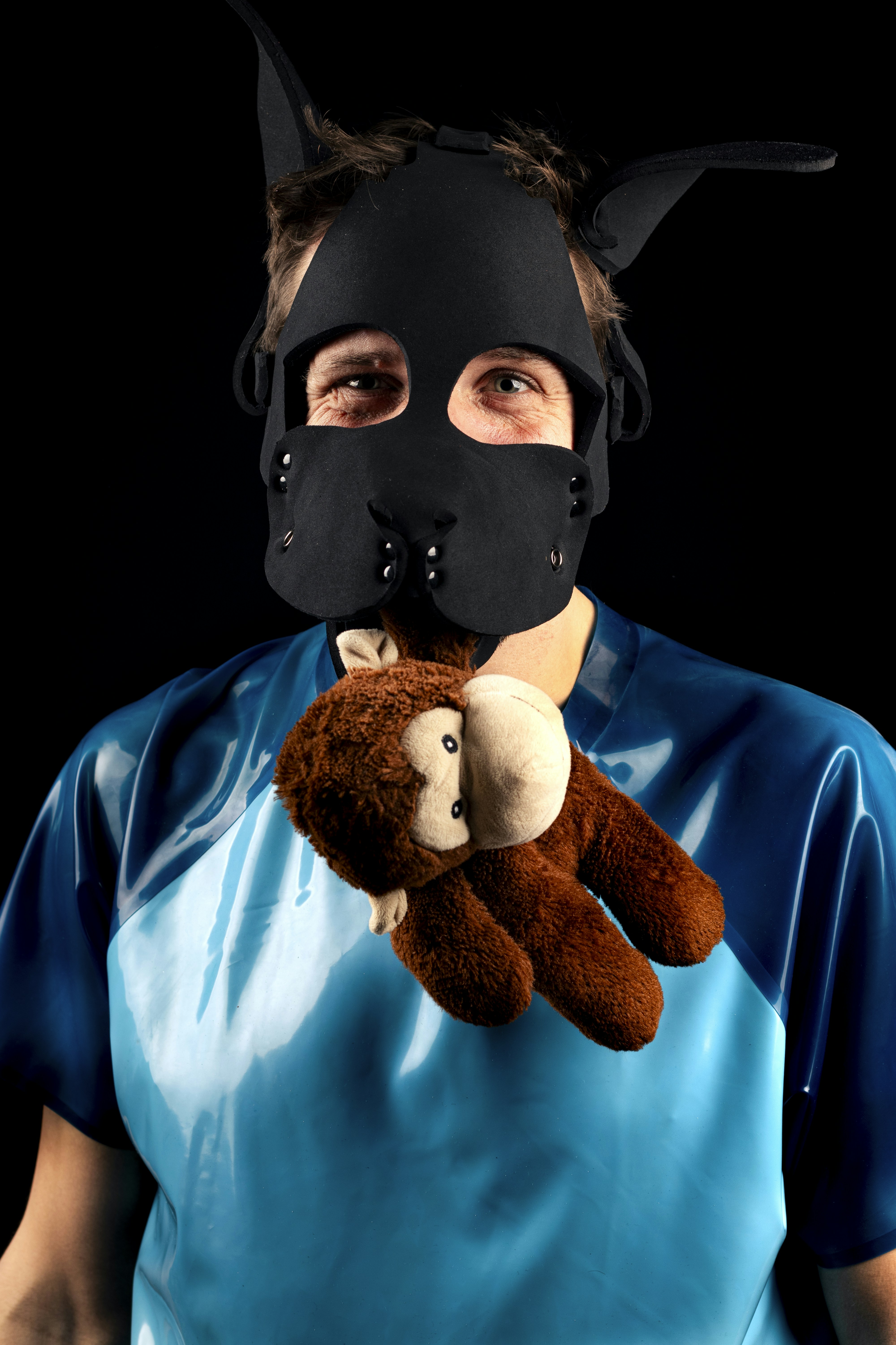 Homme masqué de chien avec singe en peluche