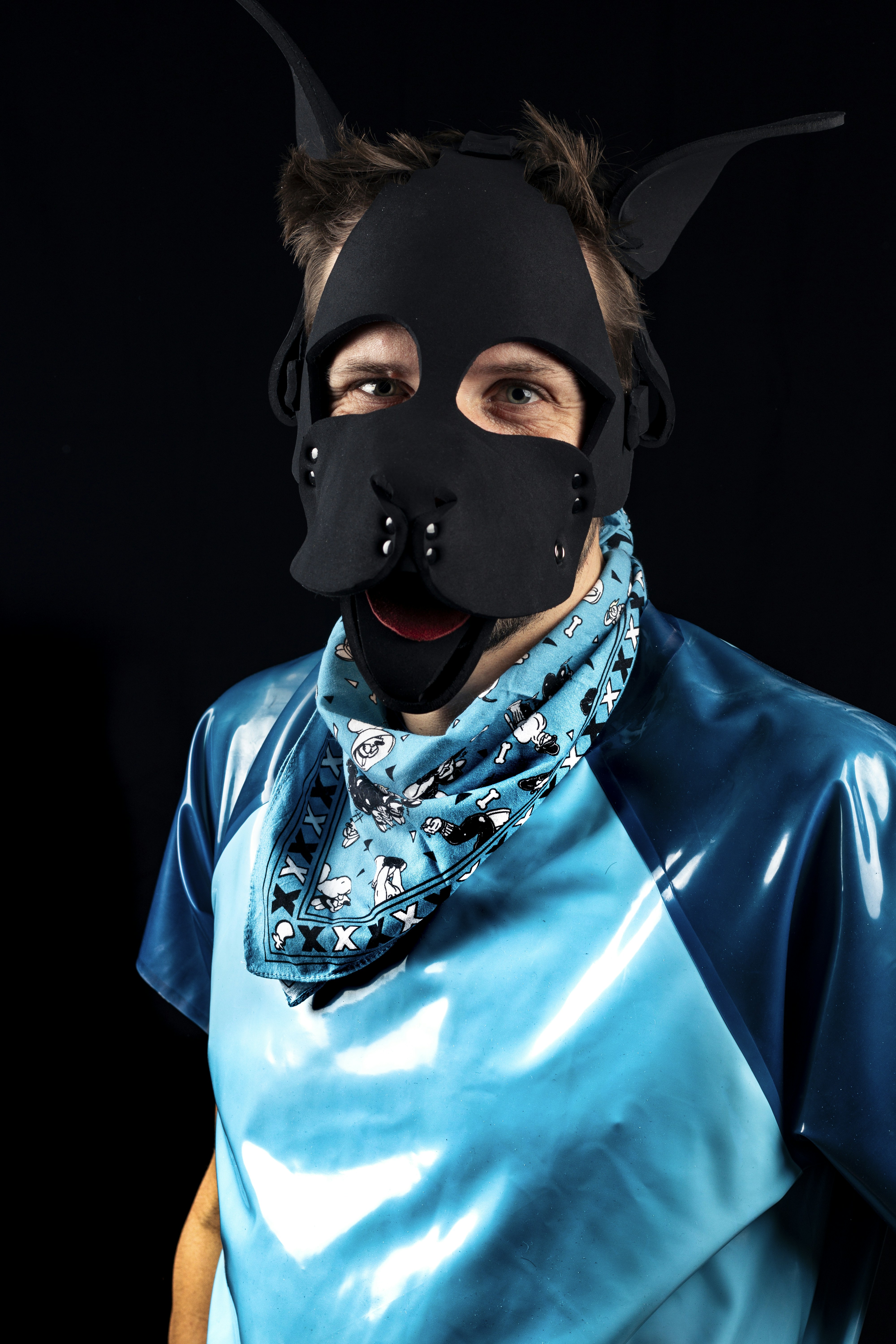Homme portant un masque de chiot noir et une chemise bleue