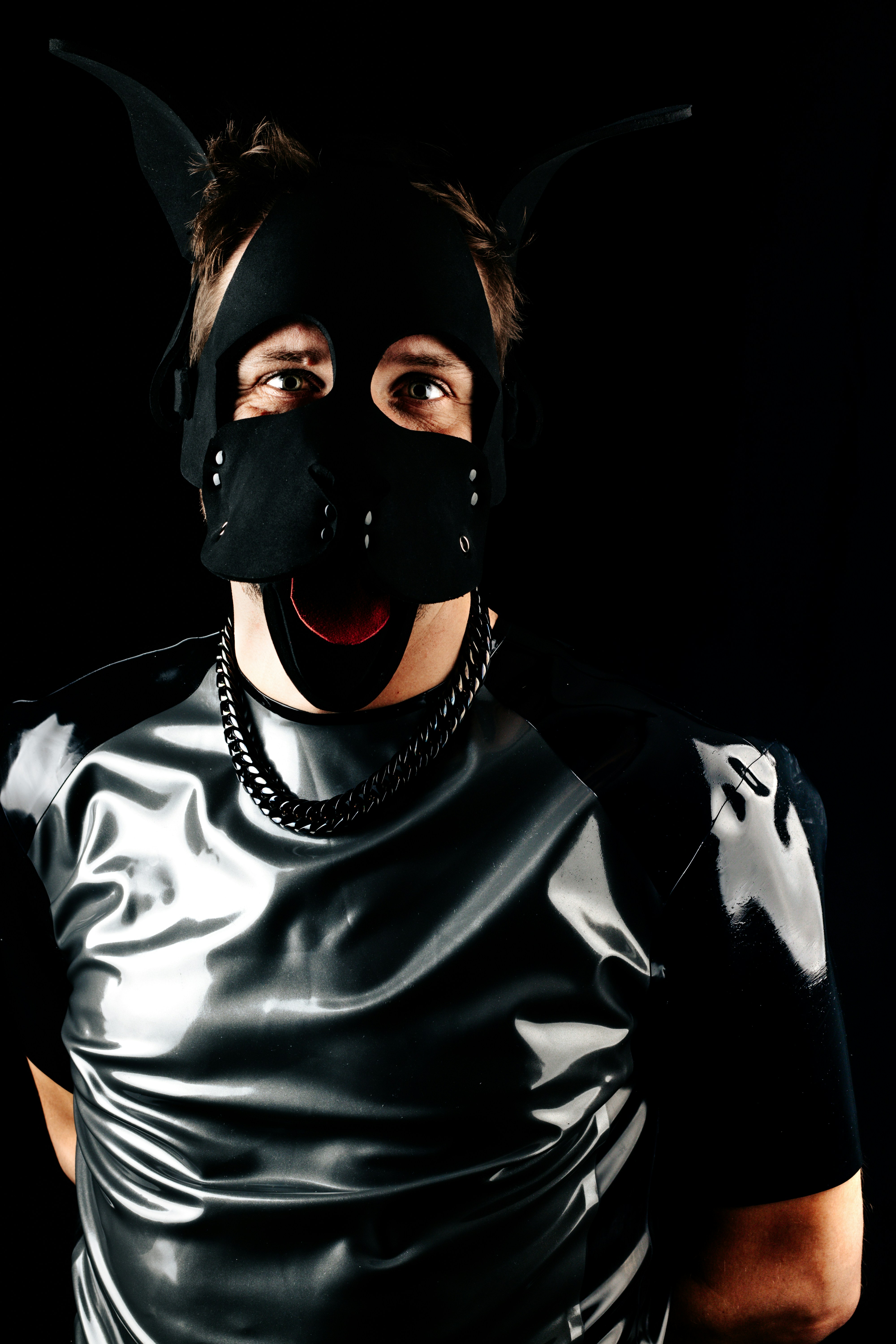 Homme portant un masque de chien noir et une chemise brillante
