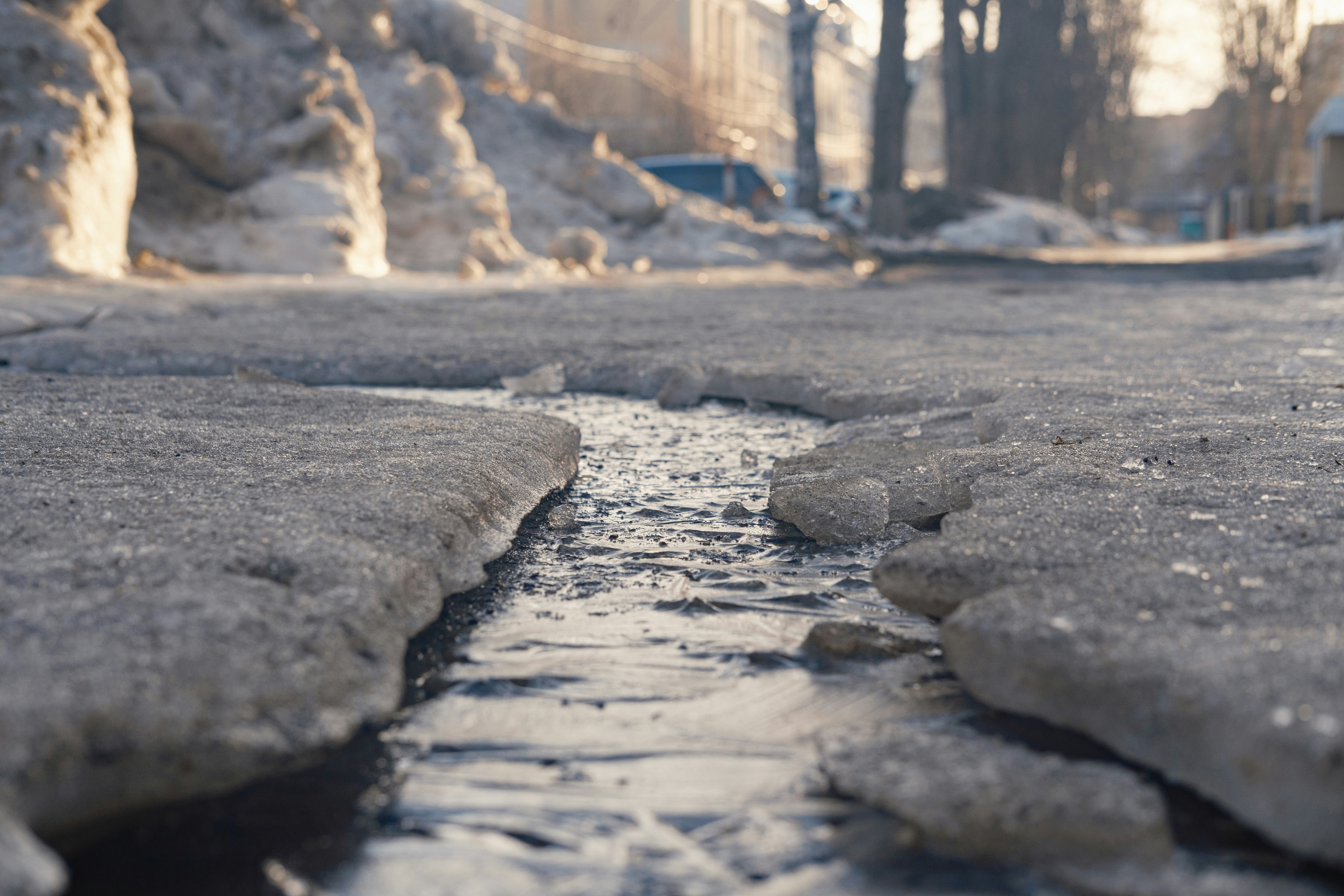 Melting snow and ice on a street in sunlight