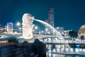Merlion statue spouting water in singapore at night