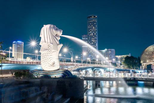 Merlion statue spouting water in singapore at night