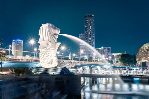 Merlion statue spouting water in singapore at night
